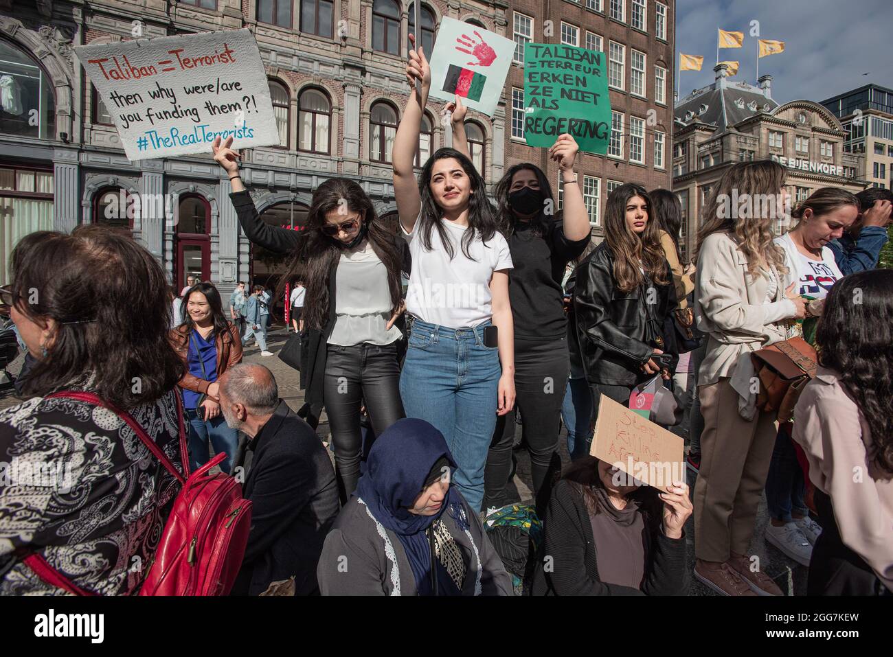 Les manifestants tiennent des écriteaux exprimant leur opinion pendant la manifestation. Plus d'un millier de personnes se sont rassemblées pour manifester sur la place du Dam, pour montrer leur soutien à la récente détresse des Afghans, maintenant à la merci des Taliban. Le gouvernement néerlandais a désigné l'Afghanistan comme un pays dangereux, ce qui signifie que les réfugiés ont droit à la protection et à l'asile politique. La manifestation d'aujourd'hui a été organisée par 'Azadi', un mouvement de jeunes Afghans néerlandais, qui fait désormais partie d'un mouvement international 'Top Killing Afghans Now. Le mouvement a organisé 15 démonstrations à travers l'Europe et la citie américaine Banque D'Images