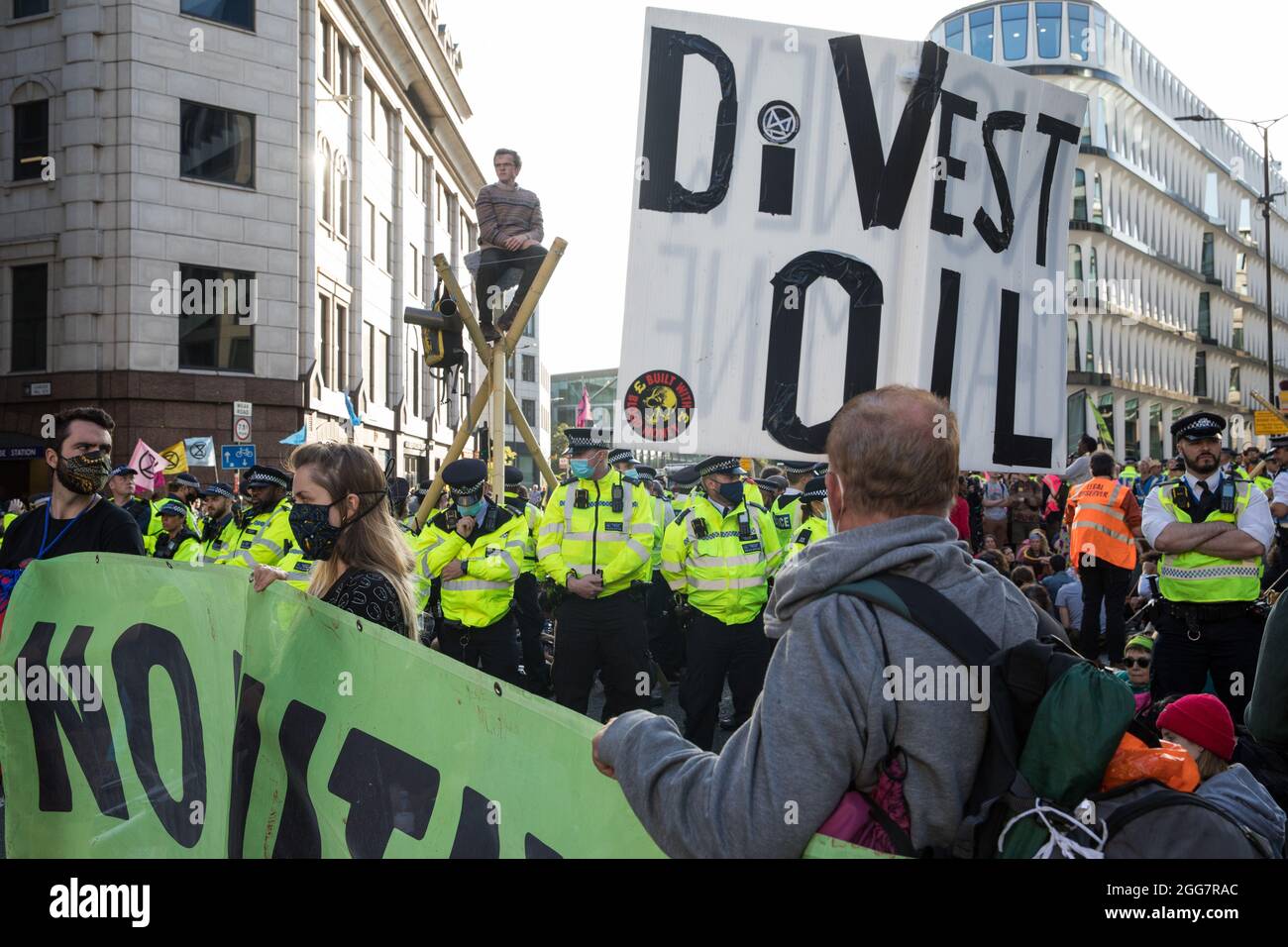 Londres, Royaume-Uni. 27 août 2021. Les militants écologistes de la rébellion d'extinction utilisent trois trépieds pour bloquer une jonction à l'extérieur de la station de métro Mansion House après une marche de l'argent du sang à travers la ville de Londres. Extinction Rebellion avait l'intention de mettre en évidence les institutions financières qui financent des projets de combustibles fossiles, en particulier dans les pays du Sud, ainsi que les cabinets d'avocats et les institutions qui les facilitent, tout en appelant le gouvernement britannique à cesser tous les nouveaux investissements dans les combustibles fossiles avec effet immédiat. Crédit : Mark Kerrison/Alamy Live News Banque D'Images