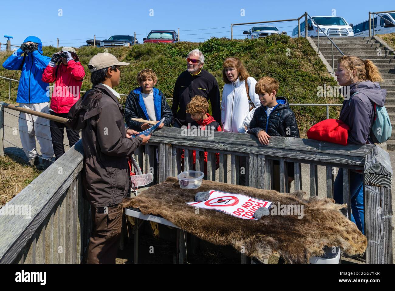 Un jeune naturaliste parle à une famille de visiteurs au phare de Yaquina Head. Oregon, États-Unis. Banque D'Images