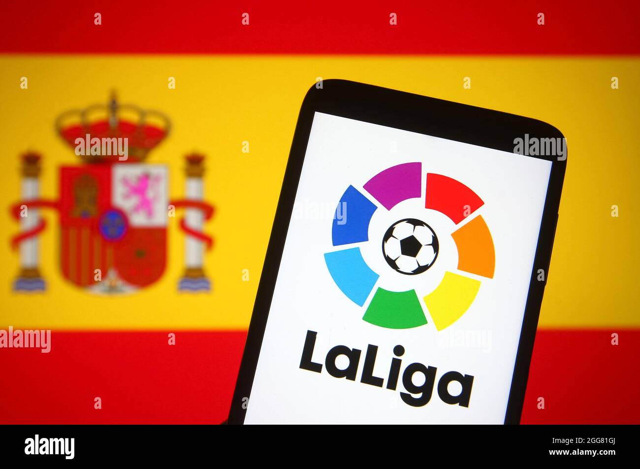 Dans cette illustration, le logo de la Ligue (Campeonato Nacional de Liga  de Primera Division) d'une ligue espagnole de football est visible sur un  écran de smartphone devant le drapeau espagnol en