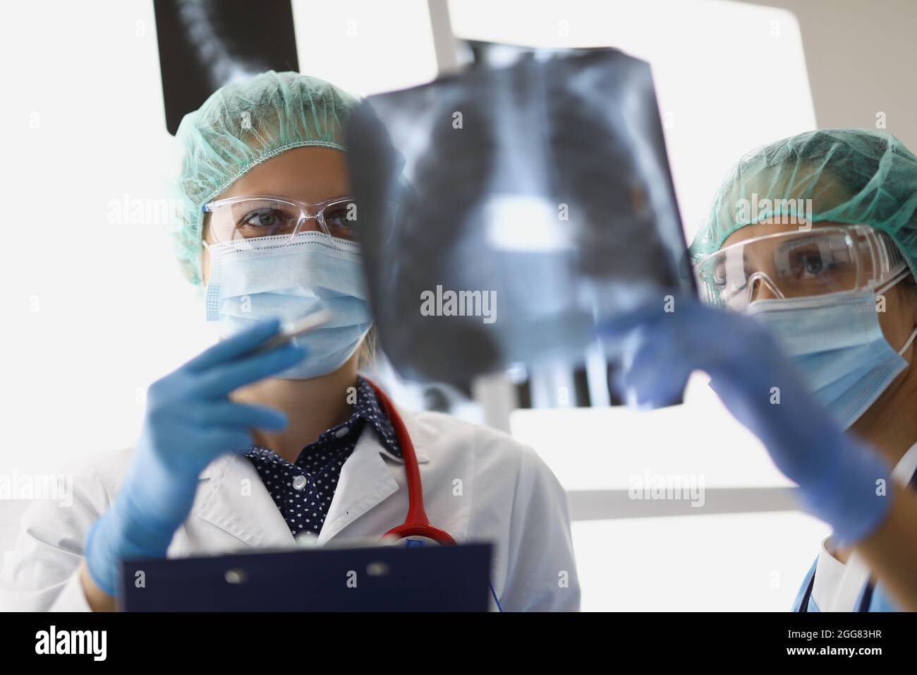 Les médecins se tiennent au bureau et regardent les rayons X. Banque D'Images