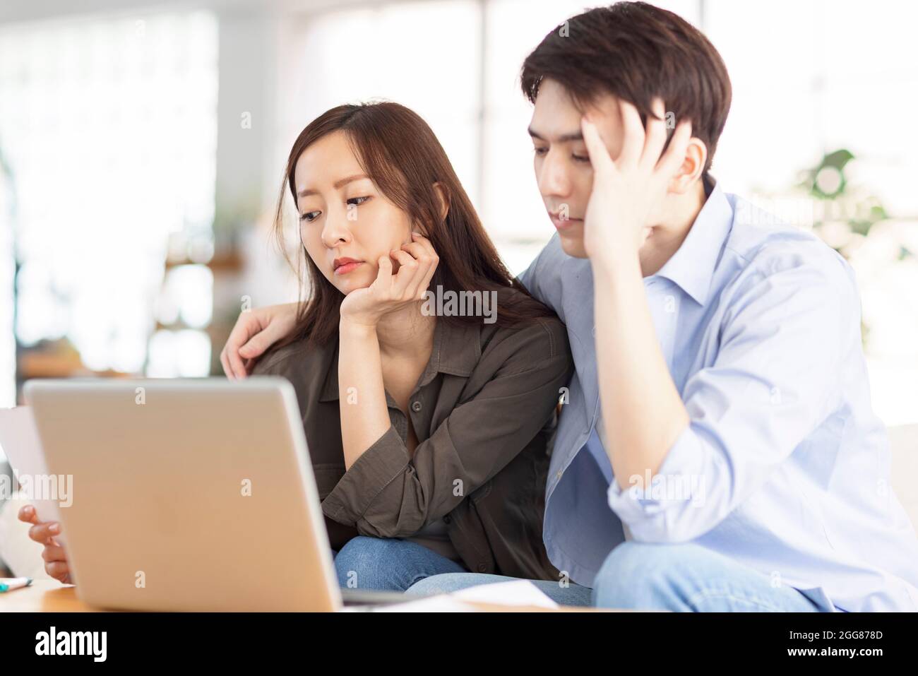 Un couple contrarié utilisant un ordinateur portable à la maison. Banque D'Images