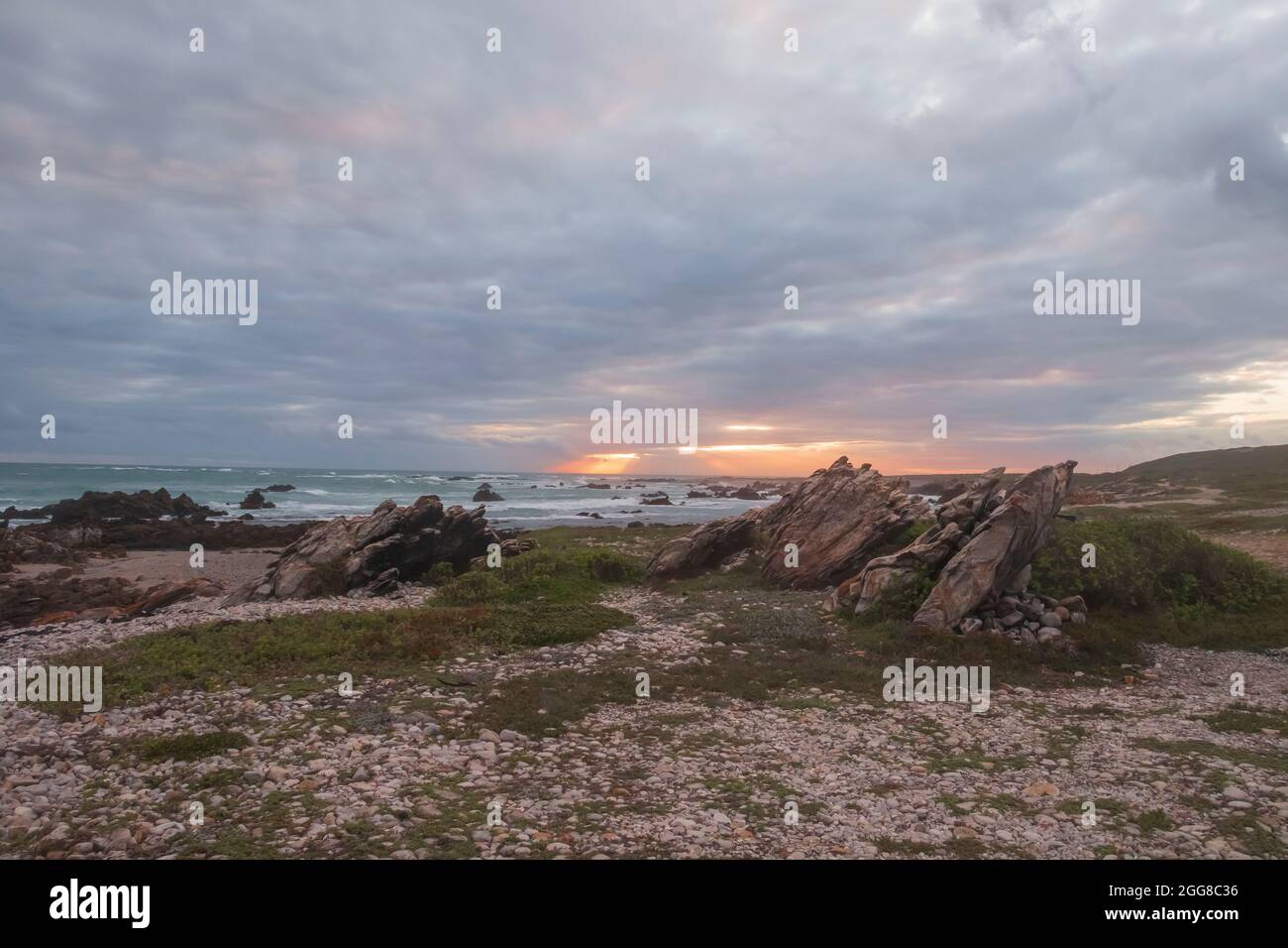 Coucher de soleil sur la côte rocheuse escarpée du parc national du Cap Agulhas en Afrique du Sud, qui est le point le plus au sud du continent africain. Banque D'Images