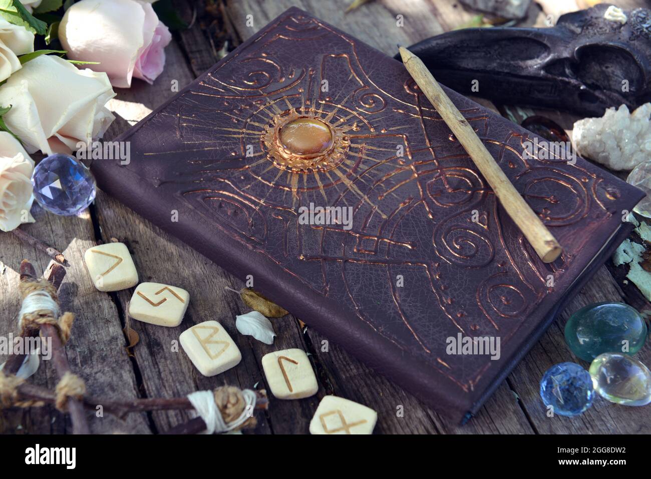 Livre de sorcière avec sorts magiques, runes et roses sur planches ...