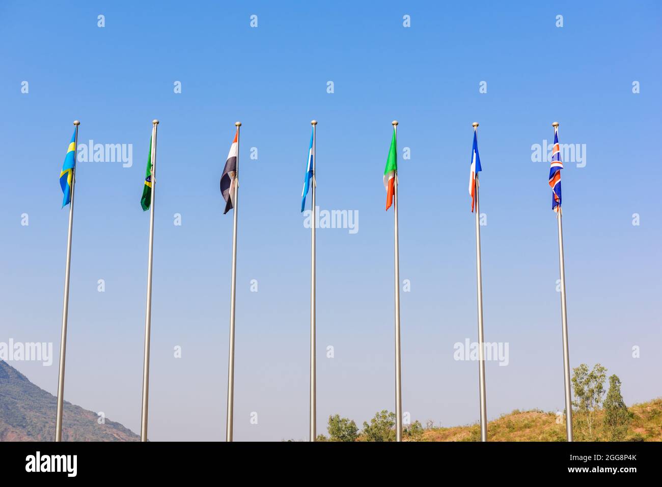 Plusieurs poteaux de drapeau de pays avec ciel bleu à l'extérieur. Banque D'Images