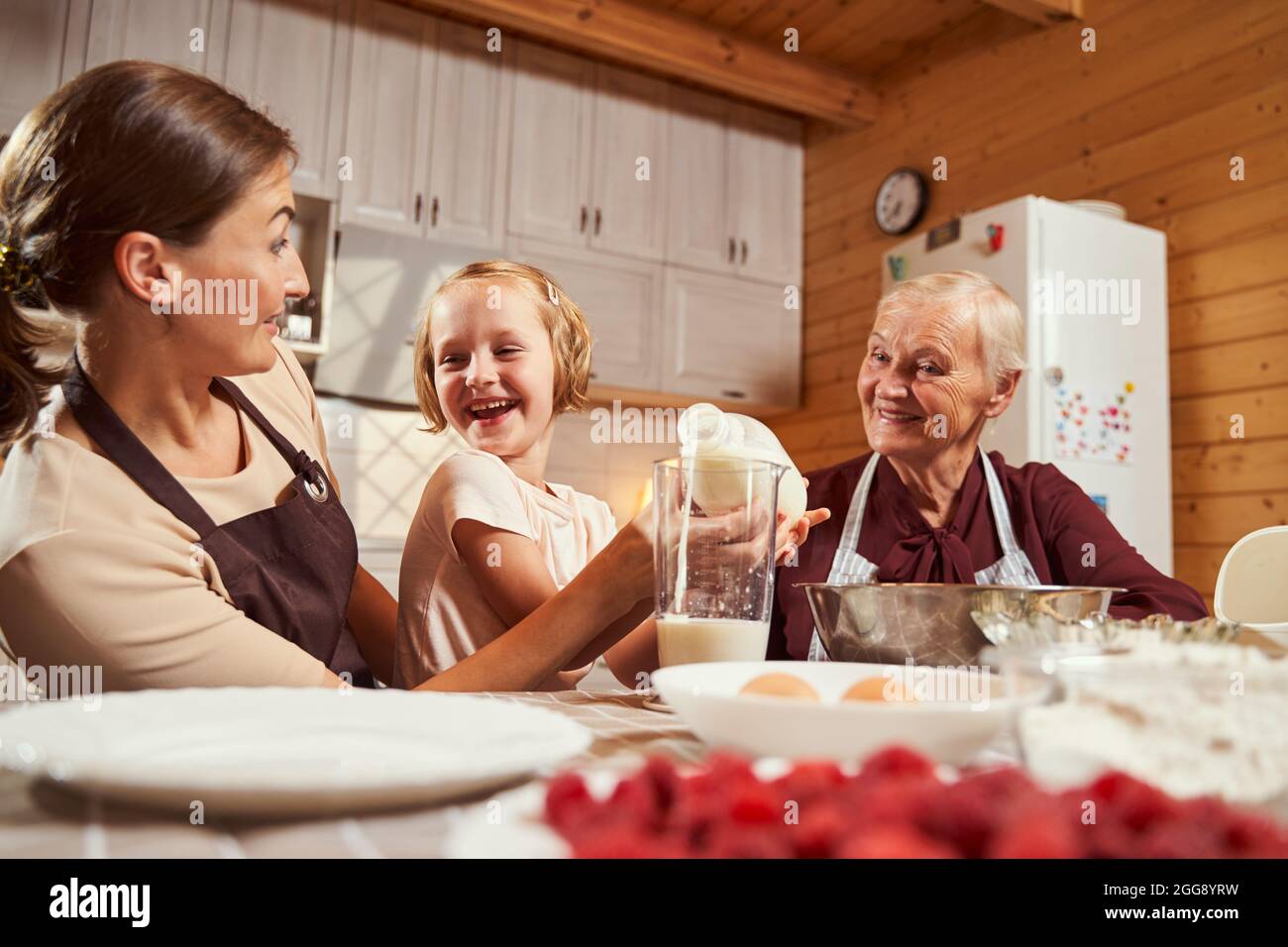 Femme âgée et femme s'amusant avec une fille tout en cuisinant Banque D'Images