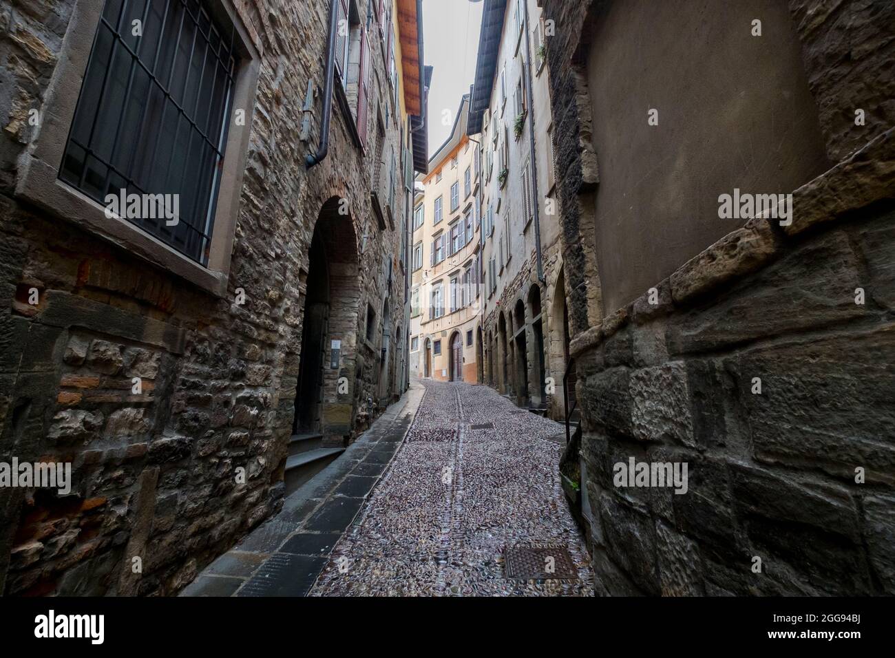 Une vue sur l'une des anciennes, vieilles, pavées, tortueuses, étroites rues, dans un après-midi de tempête et de tempête au crépuscule. Dans la section Città Alta de Bergame, N Banque D'Images