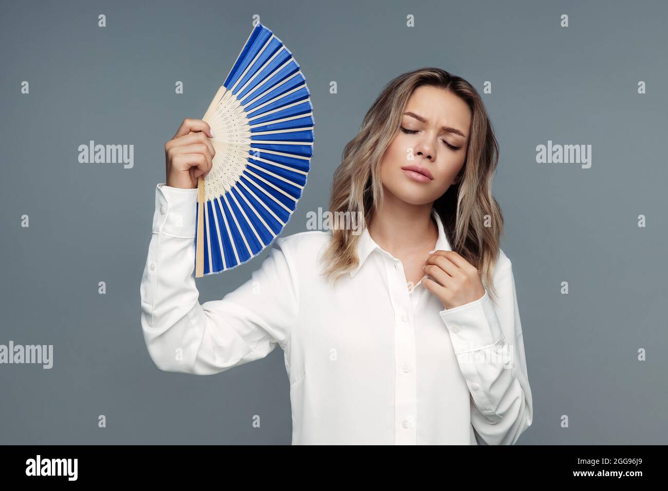 Une femme fatiguée surchauffée souffre d'une vague de chaleur ventilateur de papier pour l'air frais se sent malade de la température élevée Banque D'Images