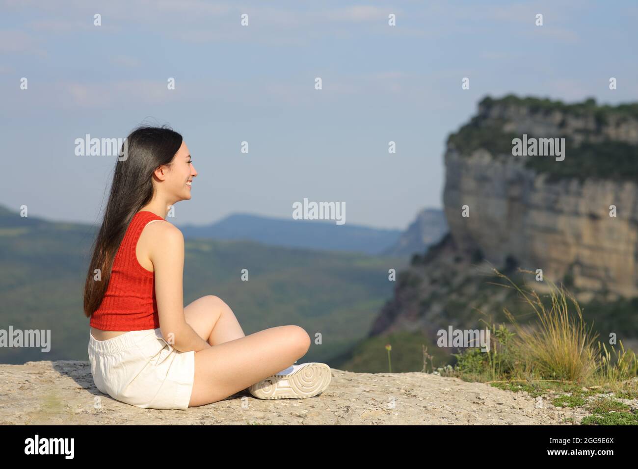 Portrait complet d'une femme asiatique contemplant une vue assise dans une falaise de montagne Banque D'Images