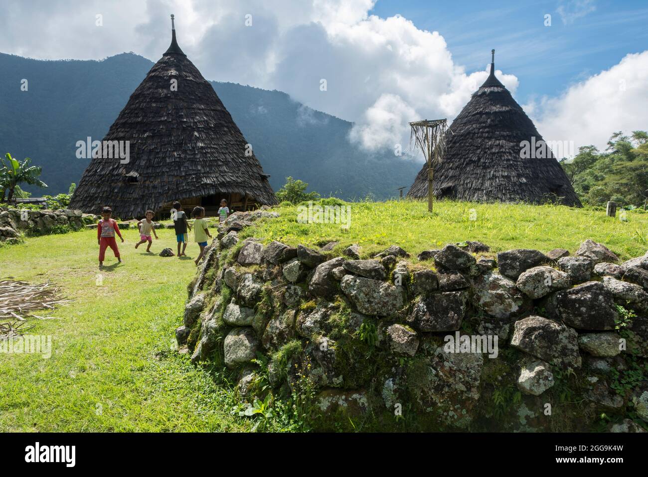 Jouer des enfants près de l'autel (Compang) du village traditionnel WAE Rebo dans les montagnes boisées de l'est Nusa Tenggara, Flores, Indonésie Banque D'Images