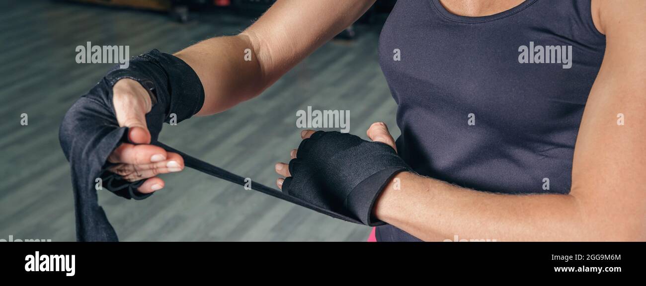 Femme enveloppant les mains avec des bandages avant l'entraînement de boxe Banque D'Images