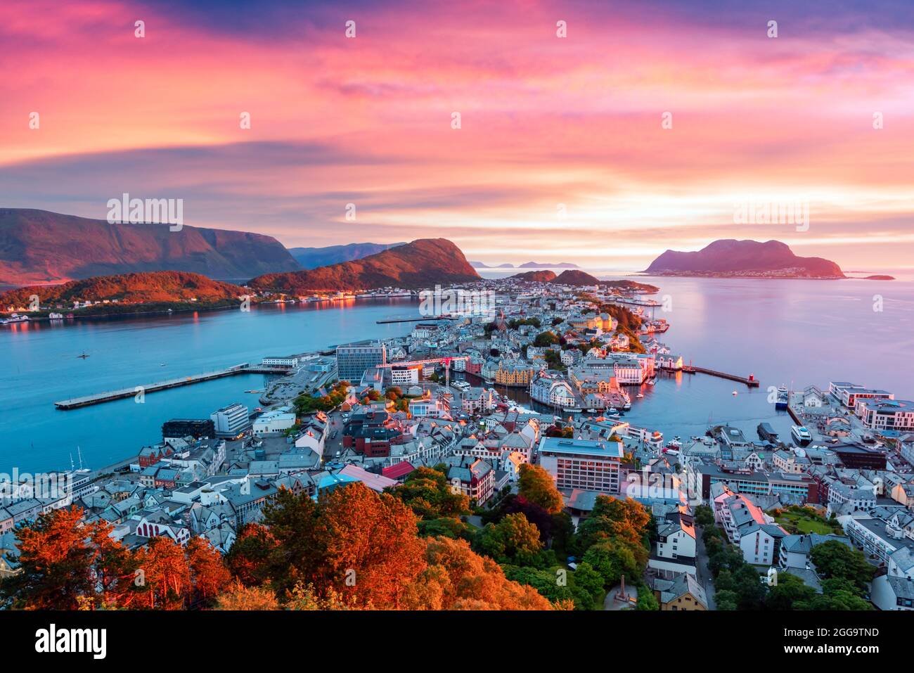 Coucher de soleil coloré dans la ville portuaire d'Alesund sur la côte ouest de la Norvège. Endroit où l'océan rencontre les montagnes. Photographie de paysage Banque D'Images