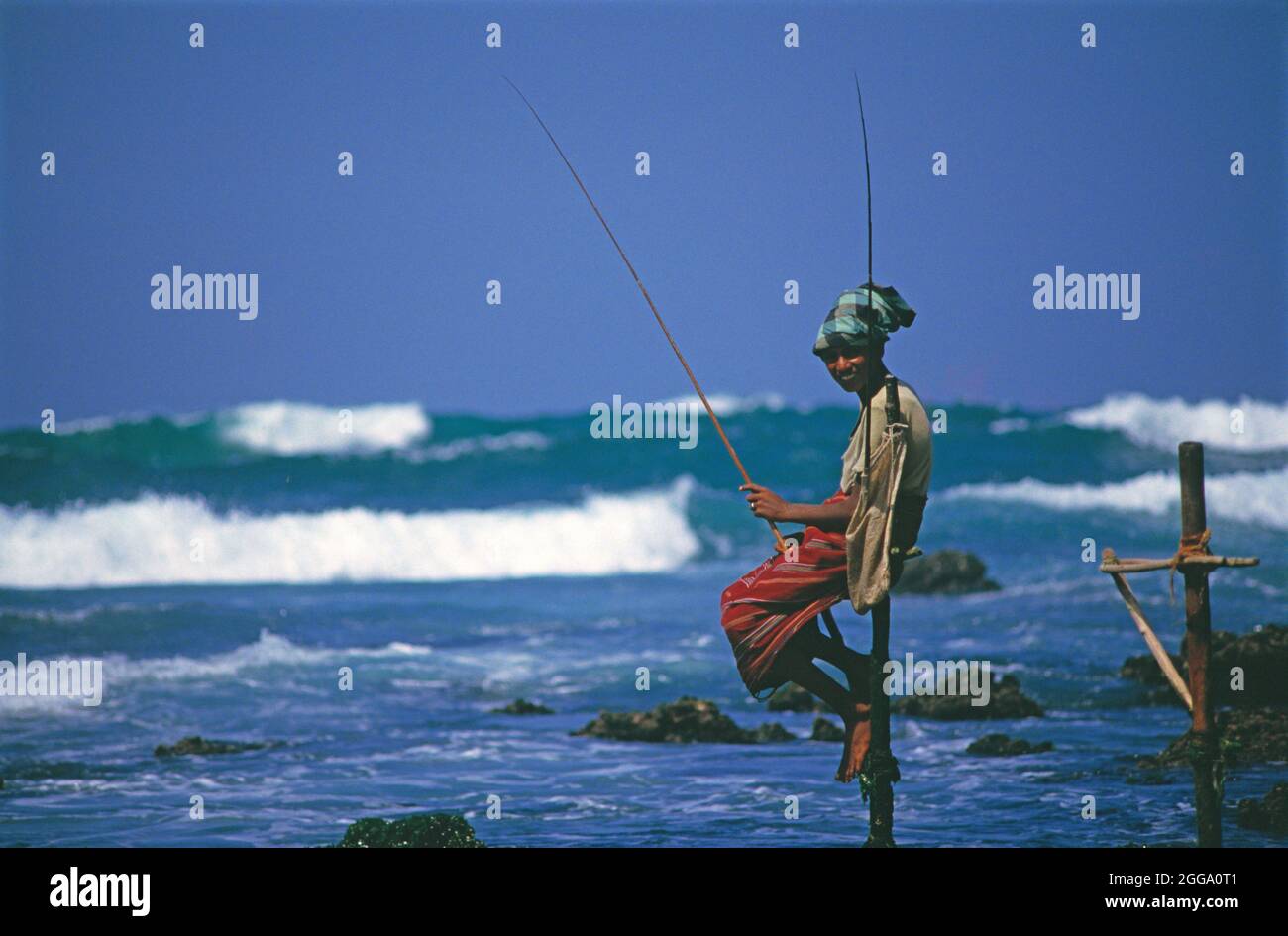Sri Lanka. Galle. Homme local pêche sur pilotis. Banque D'Images