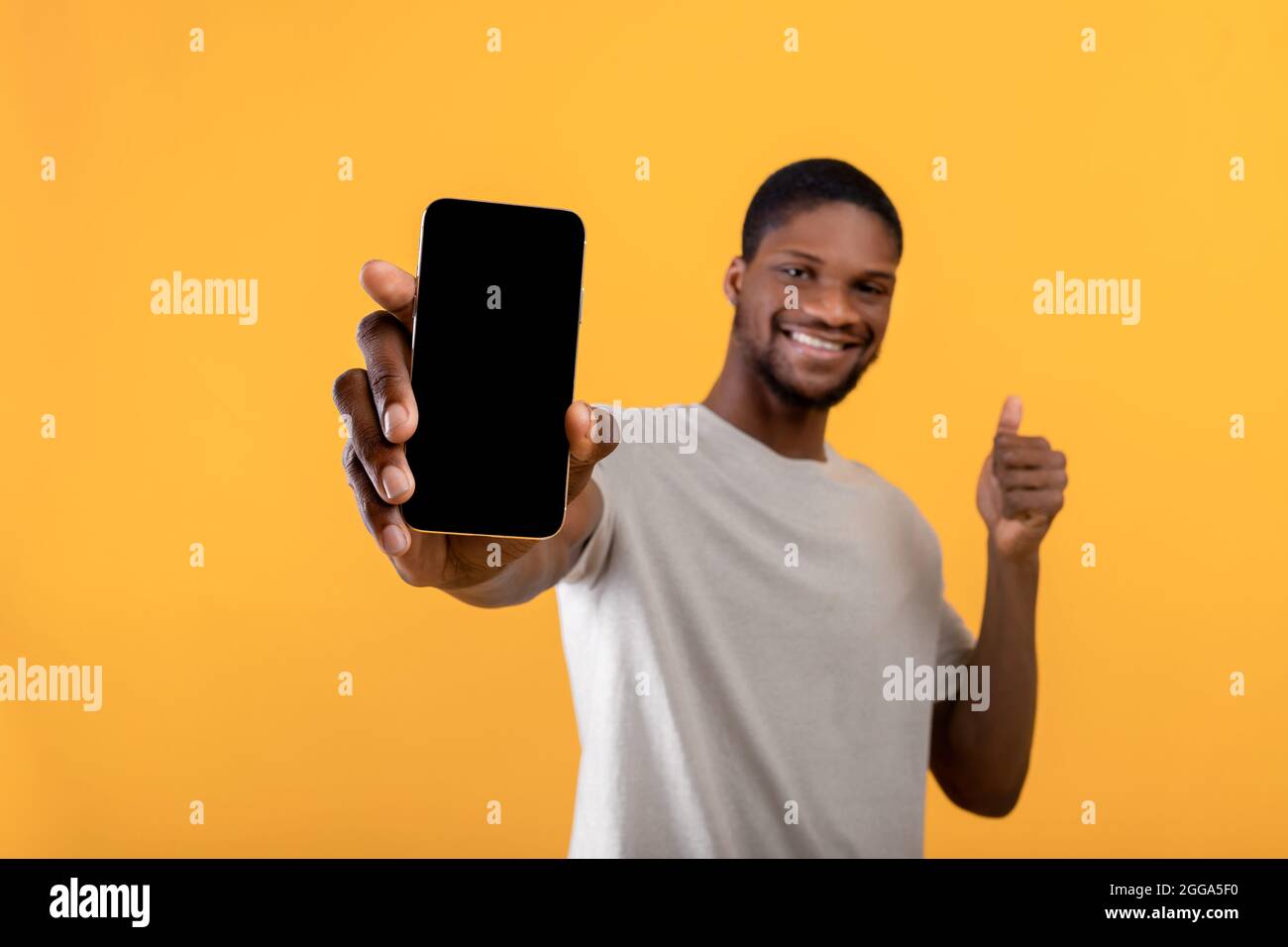 Joyeux africain américain homme de démonstration de smartphone avec écran vide, montrant l'espace de copie pour votre annonce ou de conception Banque D'Images
