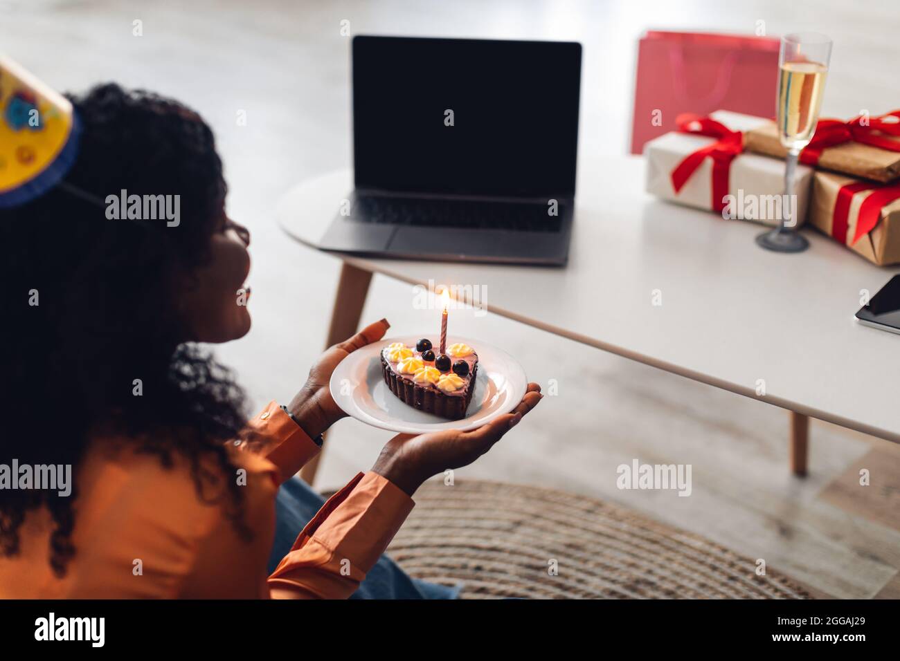 Femme Afro Americaine A L Ordinateur Portable Tenant Le Gateau D Anniversaire En Interieur Vue Arriere Photo Stock Alamy