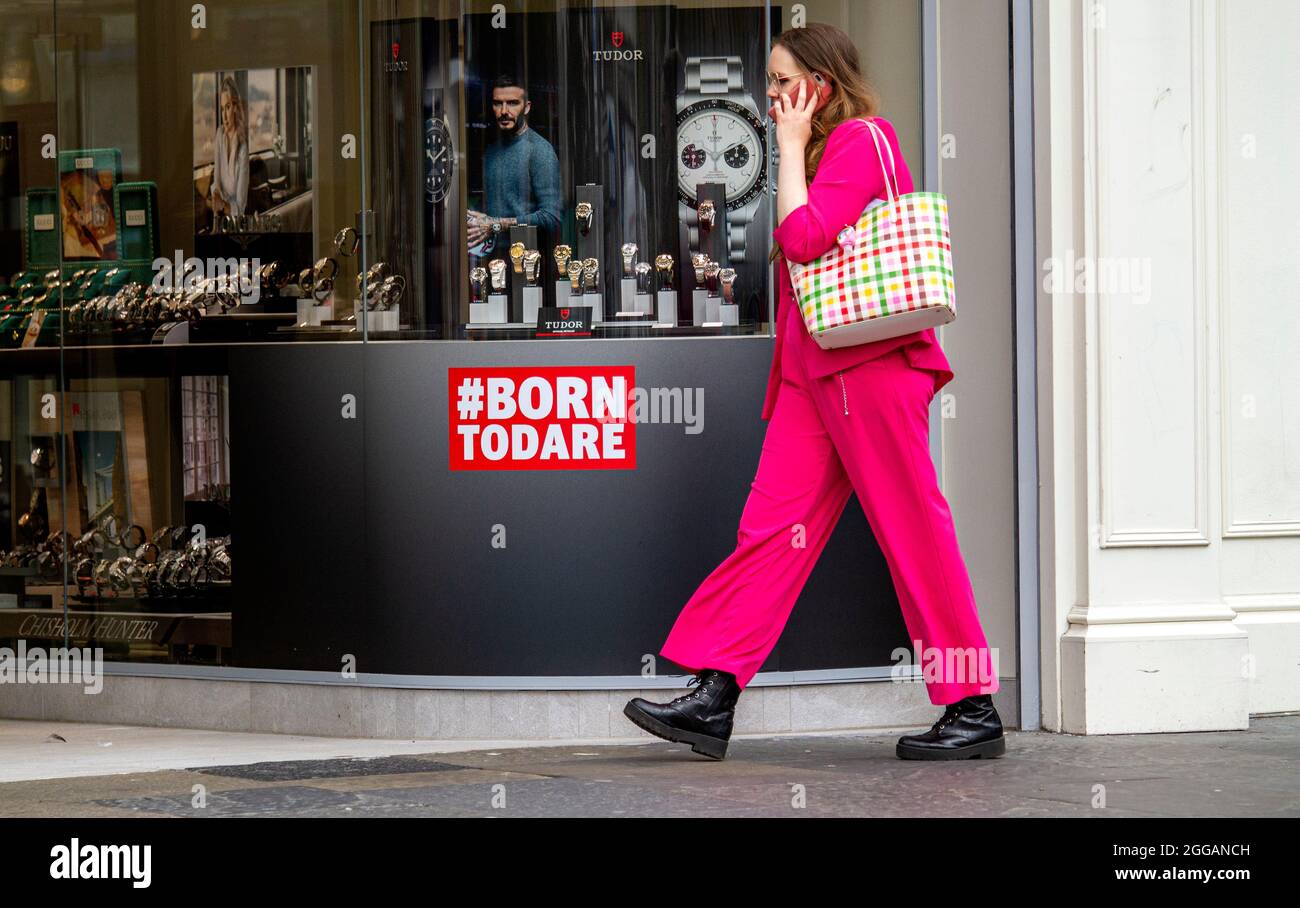 Dundee, Tayside, Écosse, Royaume-Uni. 30 août 2021. Météo au Royaume-Uni : une journée chaude et lumineuse à travers le nord-est de l'Écosse avec des températures atteignant 18°C. Bank Holiday Monday attire de nombreux résidents locaux pour profiter d'une journée de socialisation à l'extérieur après des mois de serruriers du coronavirus. Une jeune femme très tendance vêtue de vêtements roses marchant a passé l'affiche #BORN TODARE en profitant d'une journée dans le centre-ville de Dundee tout en parlant sur son mobile. Crédit : Dundee Photographics/Alamy Live News Banque D'Images