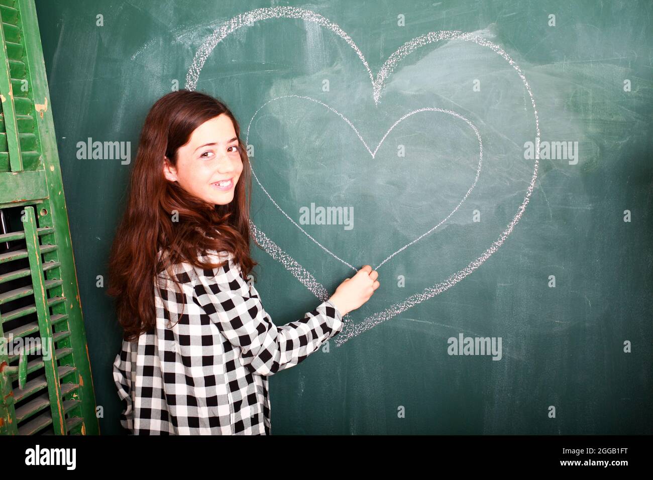 Jeune fille de 12 ans avant l'adolescence attendant l'amour à un tableau noir Banque D'Images