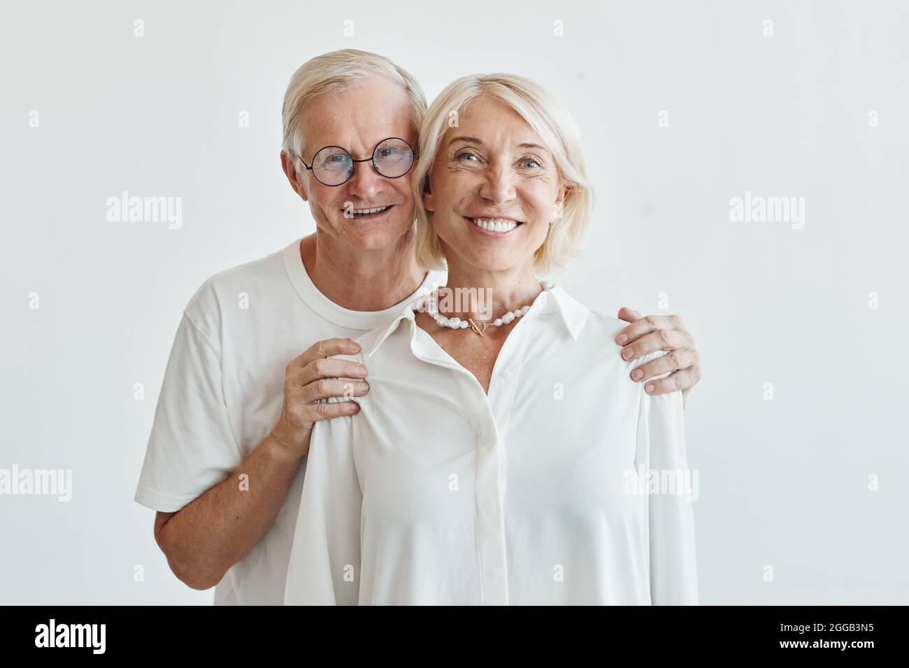 Portrait de couple senior moderne avec taille minimale, sur fond blanc et regardant l'appareil photo Banque D'Images