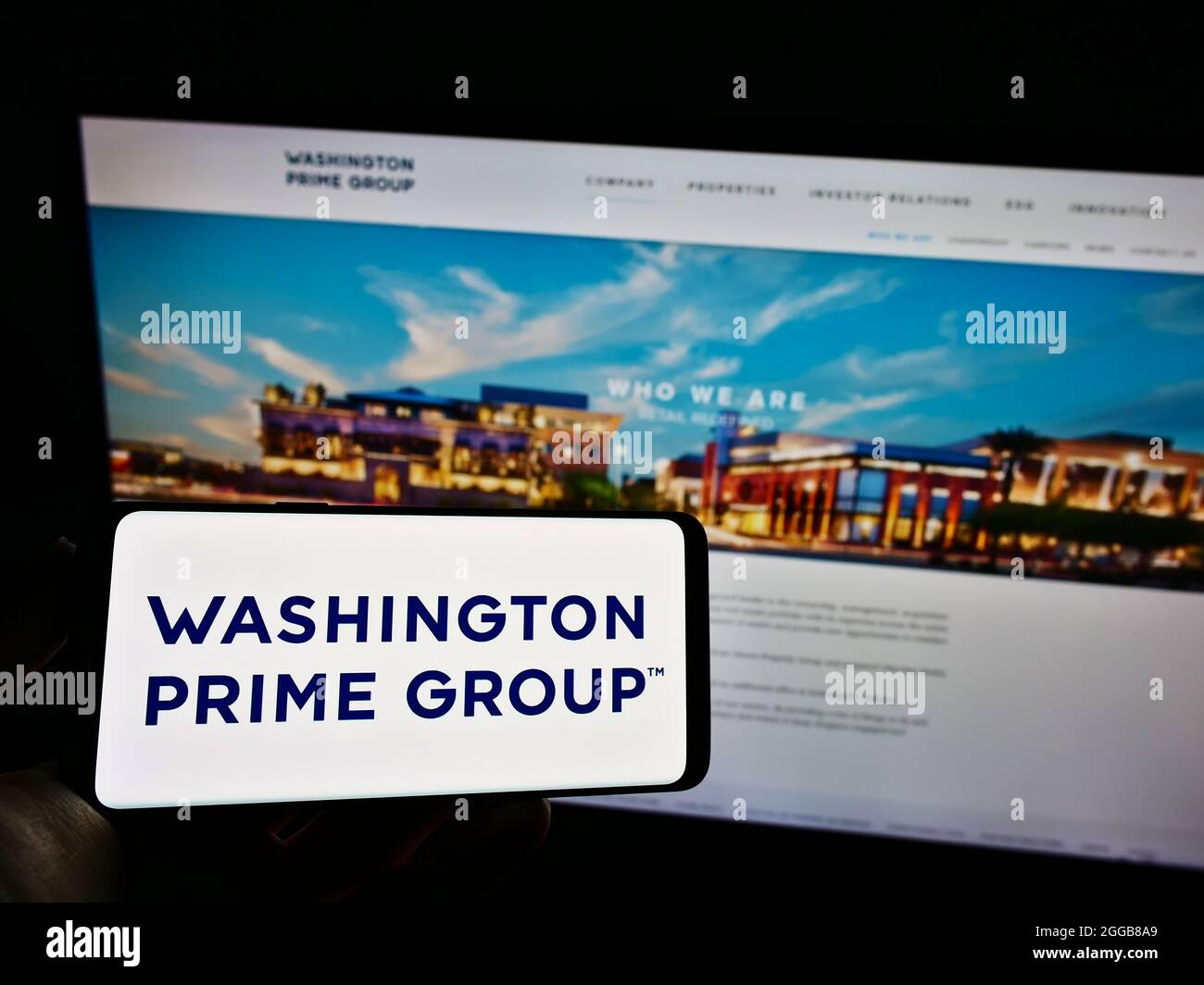 Personne tenant un téléphone portable avec le logo de la société immobilière américaine Washington Prime Group Inc. À l'écran devant la page Web. Mise au point sur l'affichage du téléphone. Banque D'Images