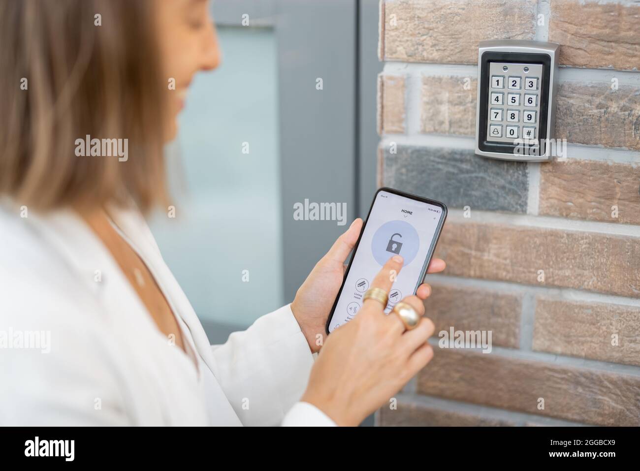 Ouverture de la porte avec un smartphone et un clavier au mur Photo Stock -  Alamy