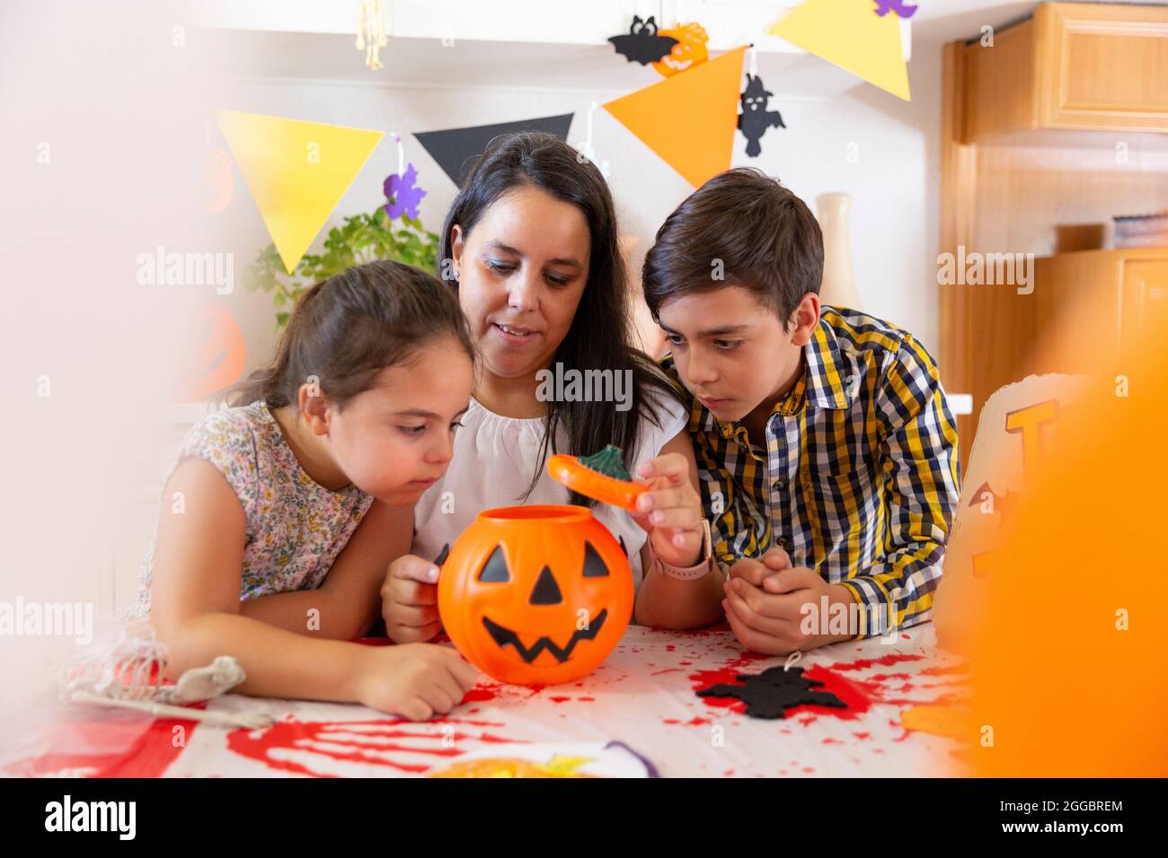 Mère avec ses deux enfants en préparation à la maison pour la fête d'Halloween. Banque D'Images