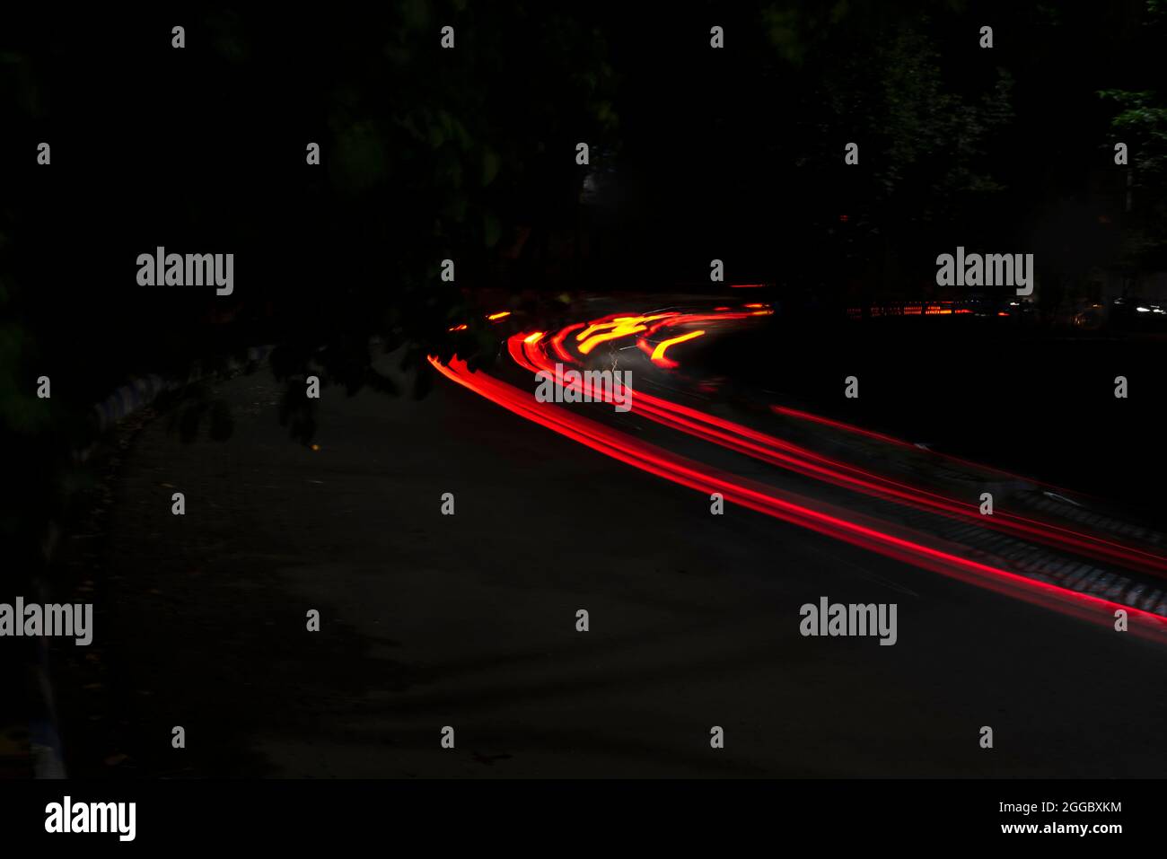 Car Light s'allume sur une rue de la ville dans une nuit noire sombre. La photo est prise avec un long exposant. Banque D'Images