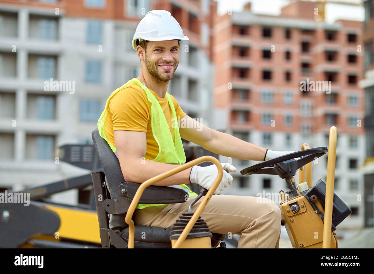 Travailleur dans un casque au volant d'un véhicule Banque D'Images