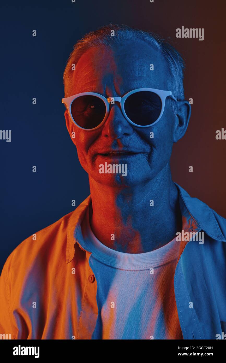 Vue de face graphique portrait en couleur d'un homme âgé portant des lunettes de soleil en rouge et bleu, espace de copie Banque D'Images