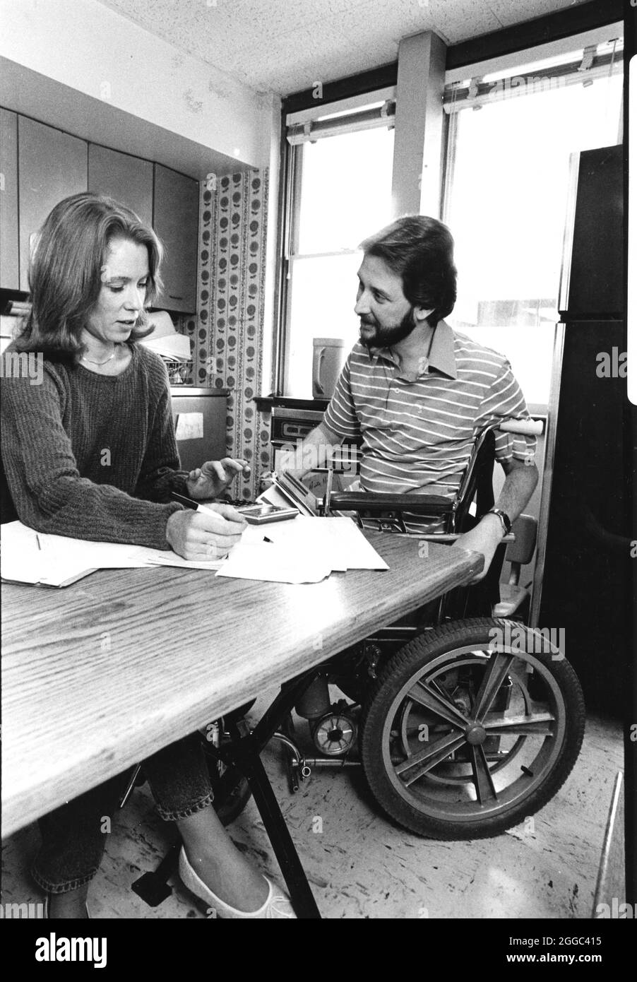 Austin Texas USA, 1993 : homme handicapé en fauteuil roulant et sa femme travaillent sur le budget du ménage et équilibrent le compte courant sur leur table de cuisine. Bob et Janis Daemmrich ©Bob Daemmrich Banque D'Images