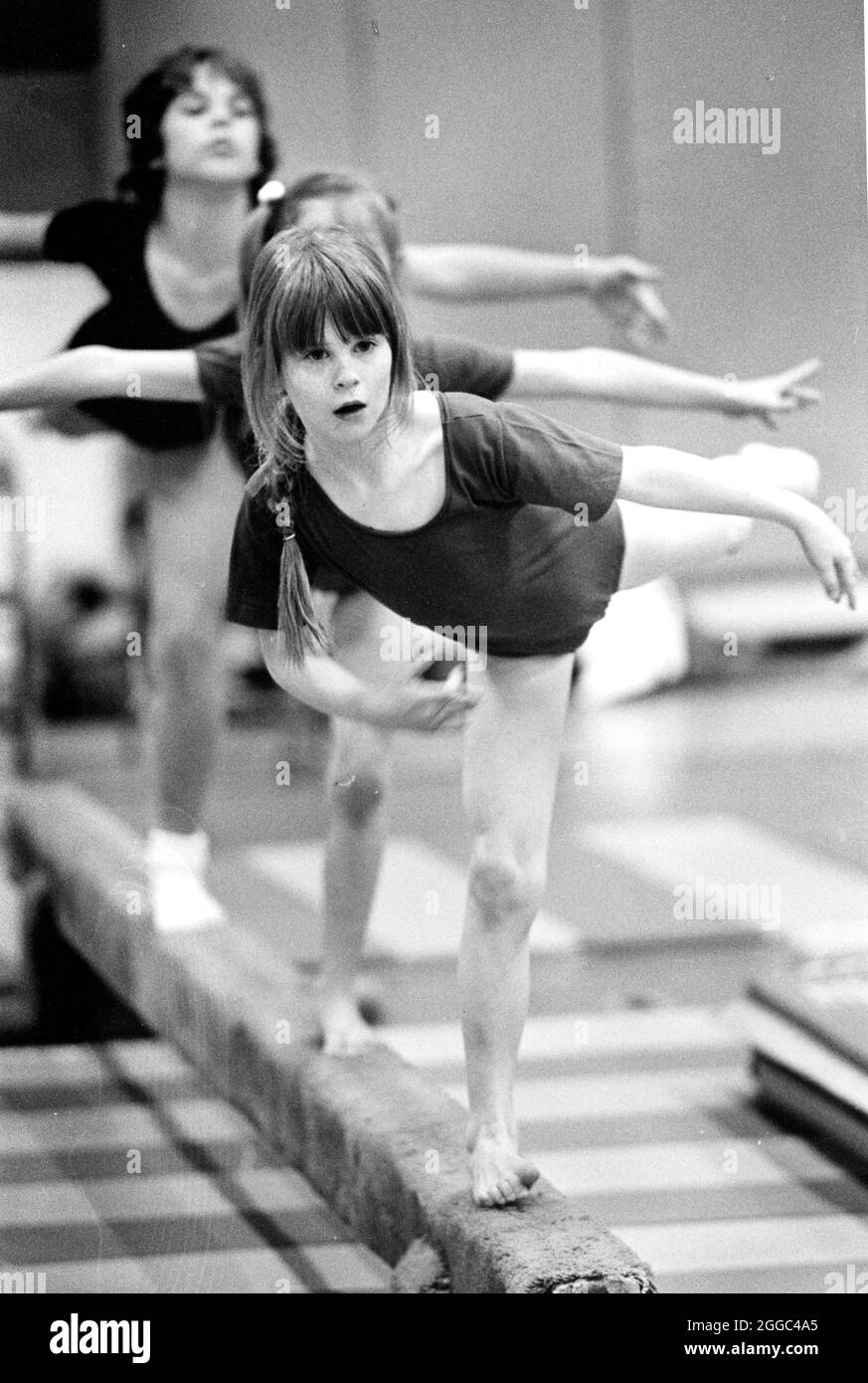 Austin Texas USA, vers 1987 : une fille de dix ans se bat pour garder son équilibre sur la poutre d'équilibre pendant les cours de gymnastique après l'école. ©Bob Daemmrich Banque D'Images