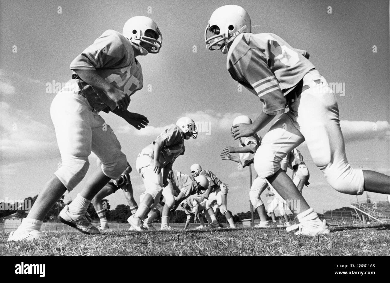 Austin Texas USA, circa 1987 : les joueurs offensifs et défensifs du lycée de la même équipe s'affrontent pendant la pratique du football. ©Bob Daemmrich Banque D'Images
