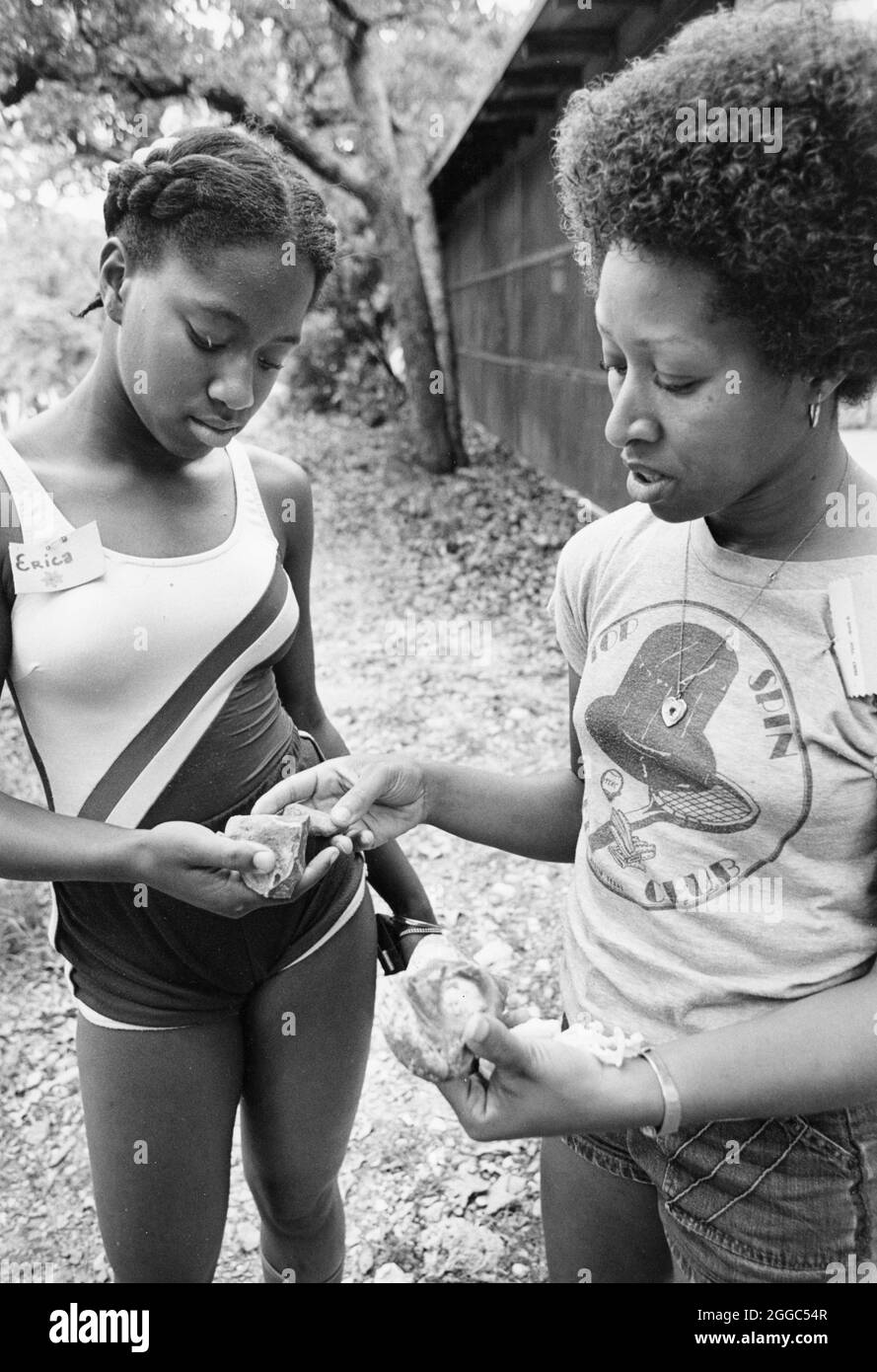 ©1990's : mère noire et fille adolescente regardent les roches qu'ils ont ramassées pendant la session extérieure de l'atelier de relation mère-fille. ©Bob Daemmrich Banque D'Images