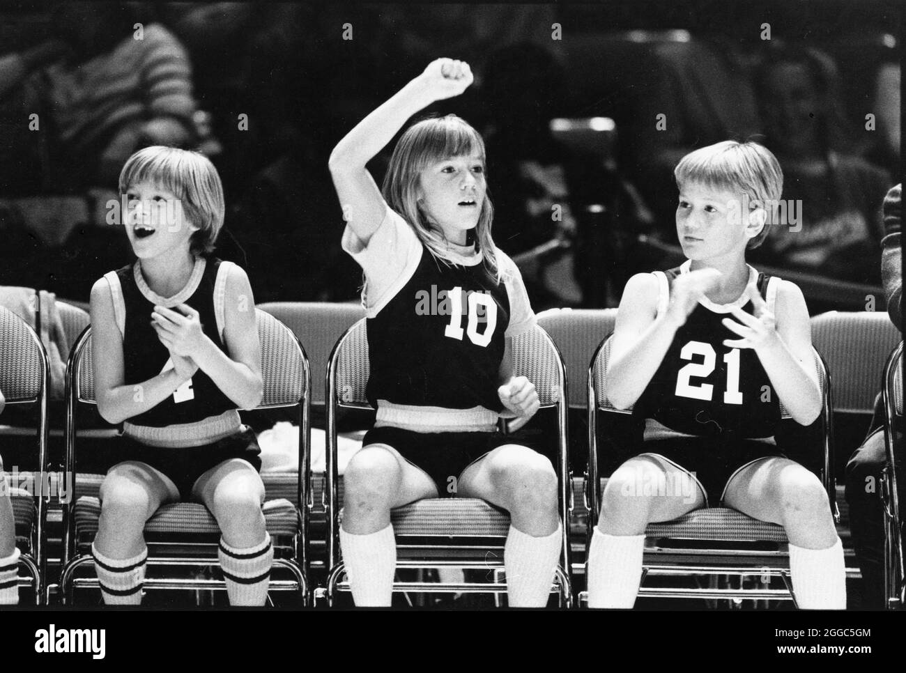 Austin Texas USA, circa 1992 : fille qui joue sur l'équipe de basket-ball garçons acclame avec ses coéquipiers sur le banc pendant le match. AUCUNE pièce d'identité ©Bob Daemmrich Banque D'Images