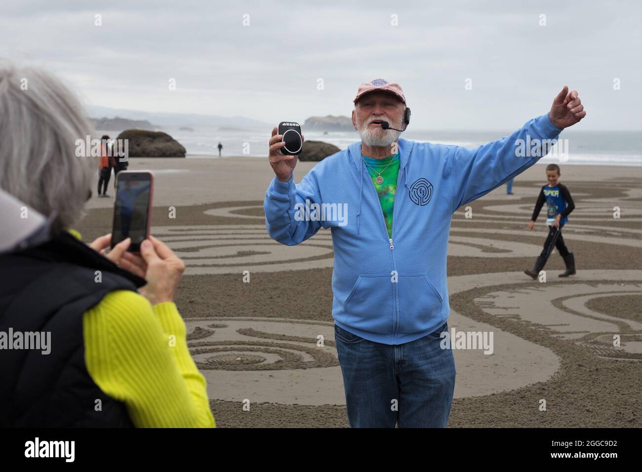 Denny Dyke, artiste du sable, parle à la foule à l'ouverture de son labyrinthe de sable, à Bandon, Oregon, États-Unis. Banque D'Images