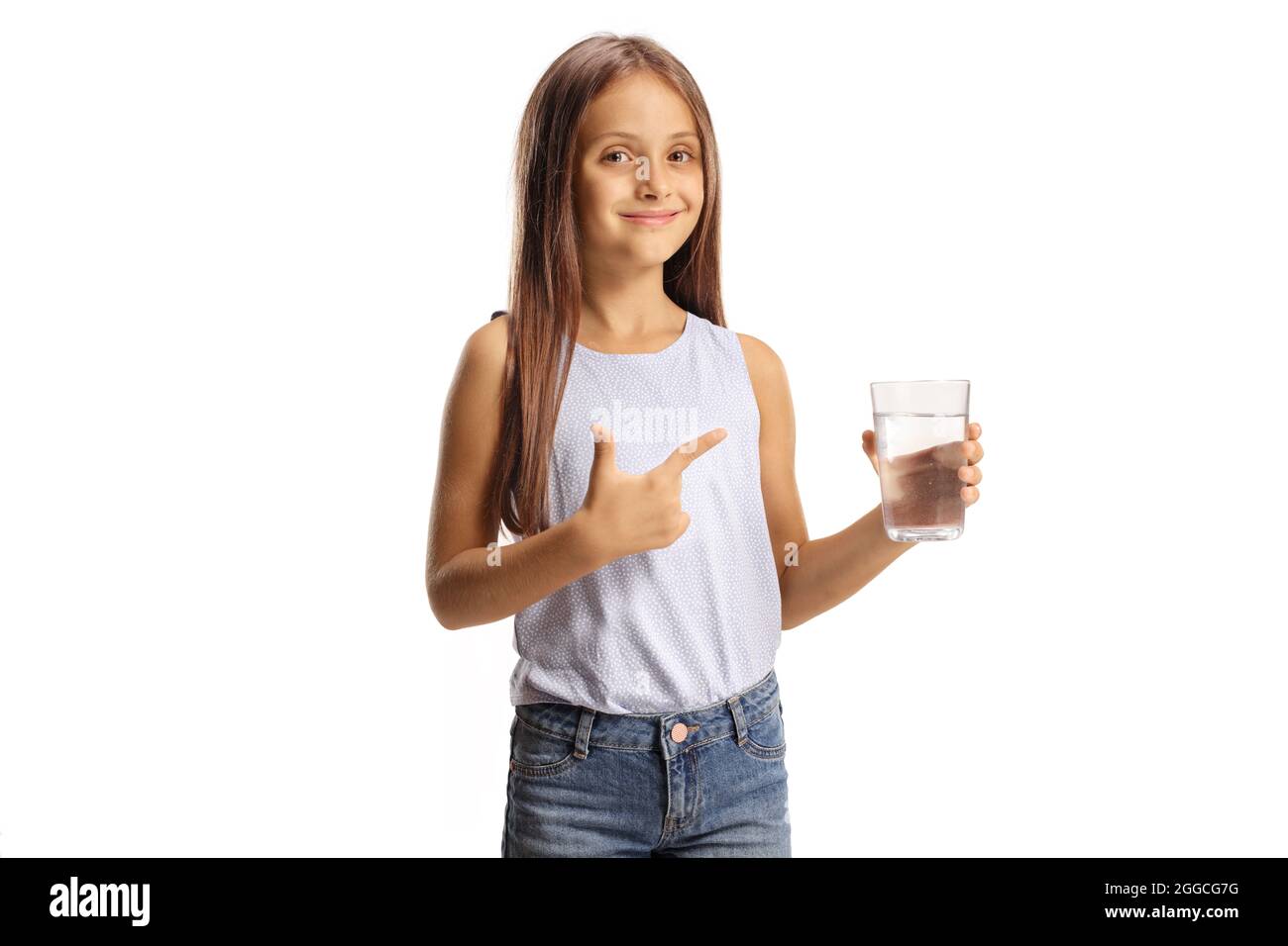 Jolie petite fille tenant un verre d'eau et pointant isolé sur fond blanc Banque D'Images