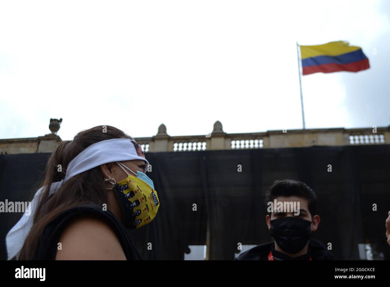 Bogota, Colombie. 30 août 2021. Une mère d'un 'faux positif' donne une interview pendant que le drapeau colombien est brandi, lors de la performance effectuée sur la Plaza de Bolívar par des militants universitaires et des mères des 'faux positifs' (meurtres de civils innocents passés comme victimes de guérilla au combat) à Bogota, Colombie le 30 août, 2021 crédit : long Visual Press/Alamy Live News Banque D'Images