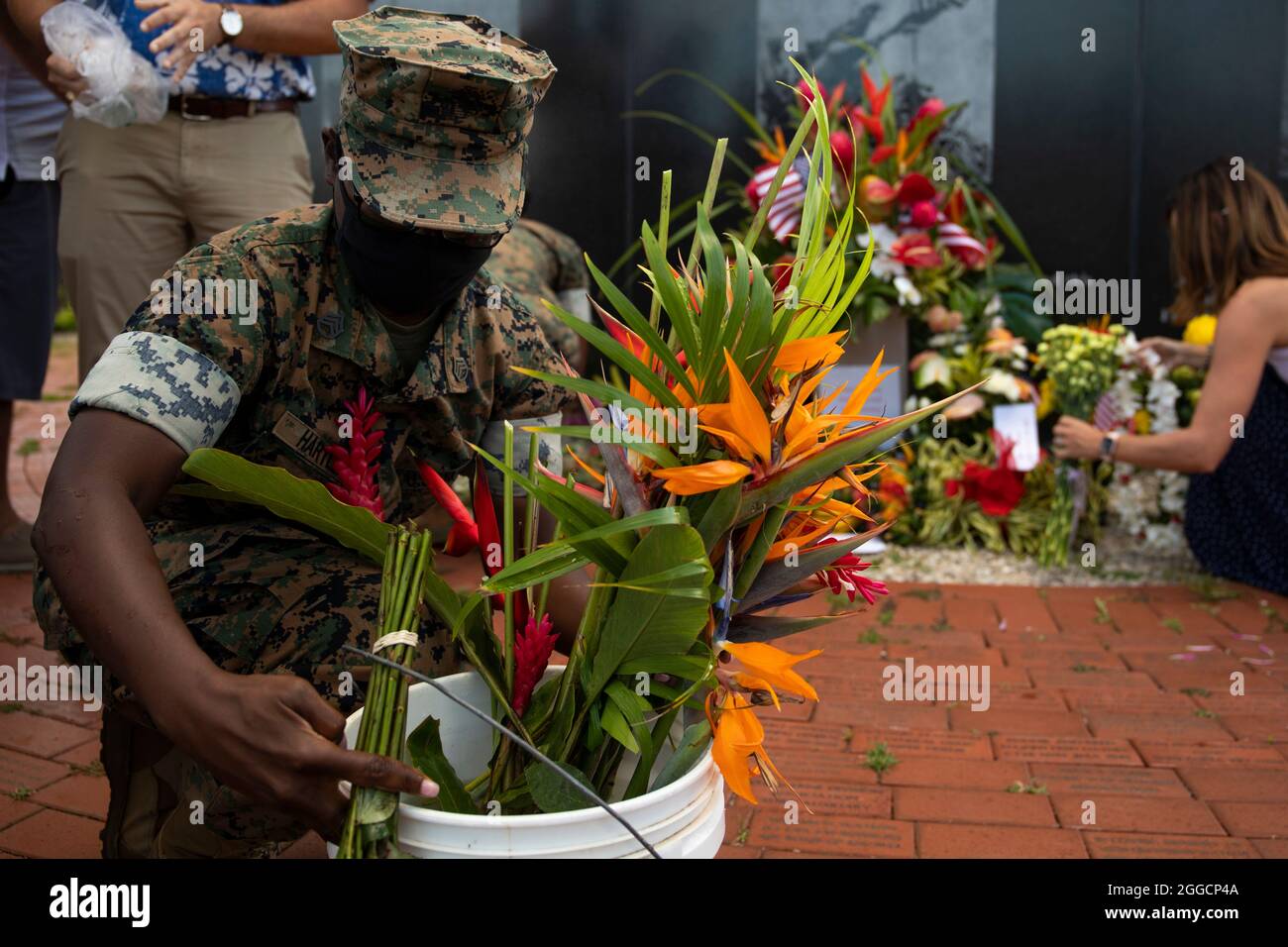 Sergent d'état-major des Marines des États-Unis Gracia Hartley, chef administratif de la base des Marines d'Hawaï, organise des bouquets floraux apportés par des membres de la communauté locale au Pacific War Memorial lors d'une cérémonie tenue en souvenir des morts à bord de la MCBH, le 29 août 2021. Pour appuyer les 13 membres du service qui ont perdu la vie en Afghanistan, les membres de la communauté ont apporté des fleurs pour être placés plus tard au Mémorial de la guerre du Pacifique pour une petite cérémonie privée. (É.-U. Photo du corps marin par Gunnery Sgt. Orlando Perez) Banque D'Images