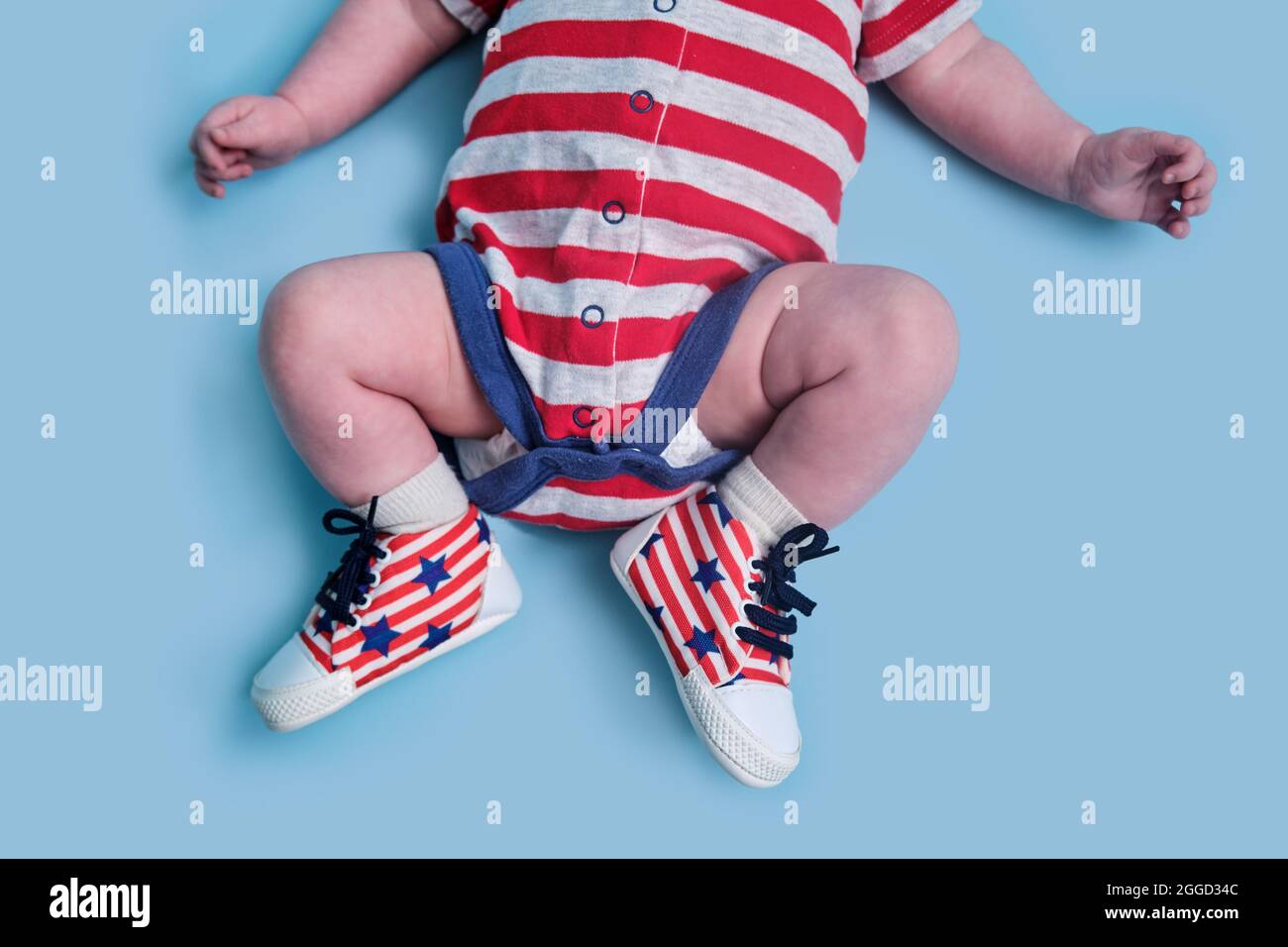 Un bébé nouveau-né vêtu des couleurs du drapeau américain des États-Unis,  fond de studio bleu. Un enfant dans les vêtements des États-Unis rouges et  blancs Photo Stock - Alamy