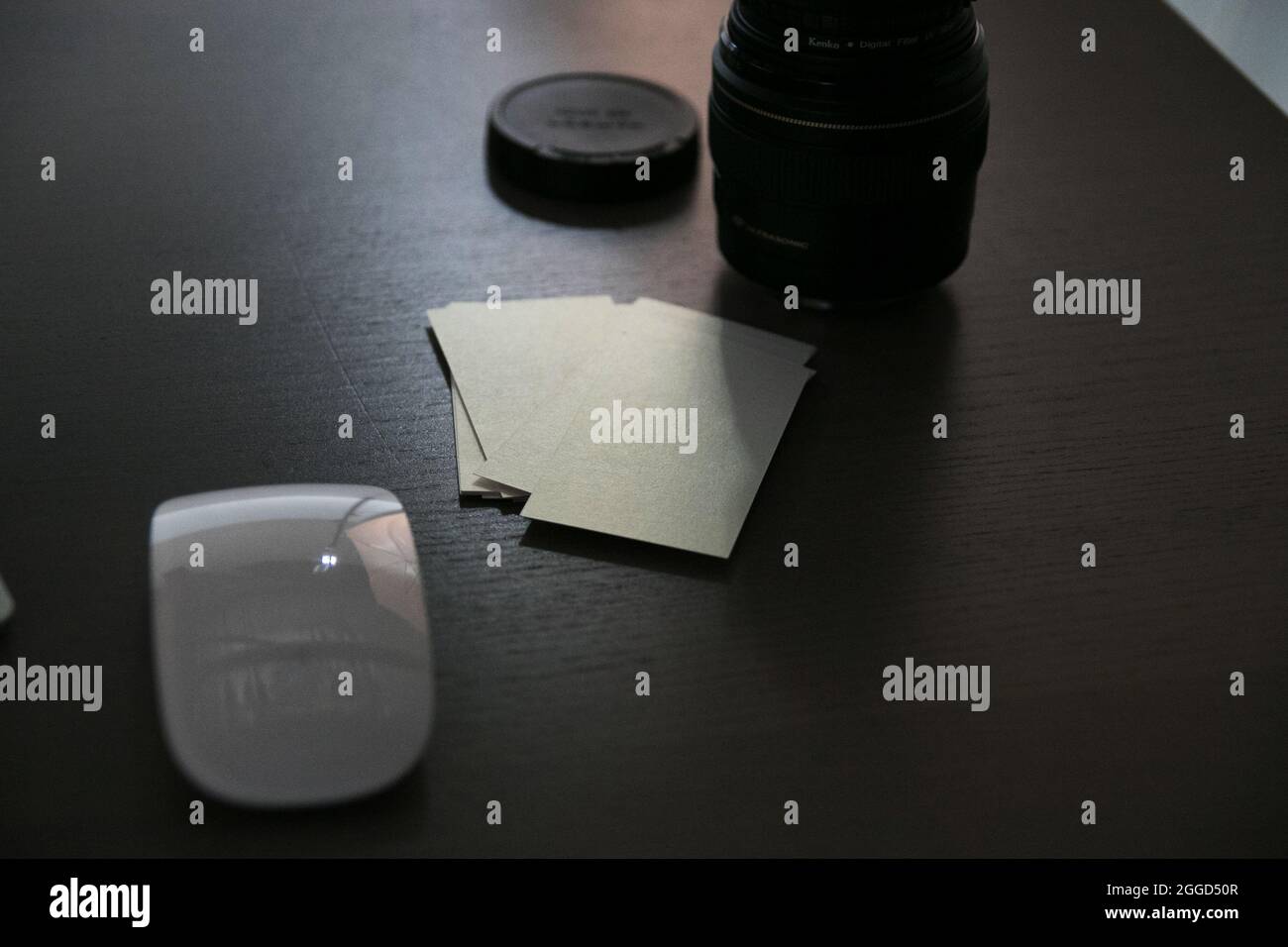 Cartes de visite blanches vierges transparentes avec accessoires numériques lentilles de souris sur le fond en bois Banque D'Images