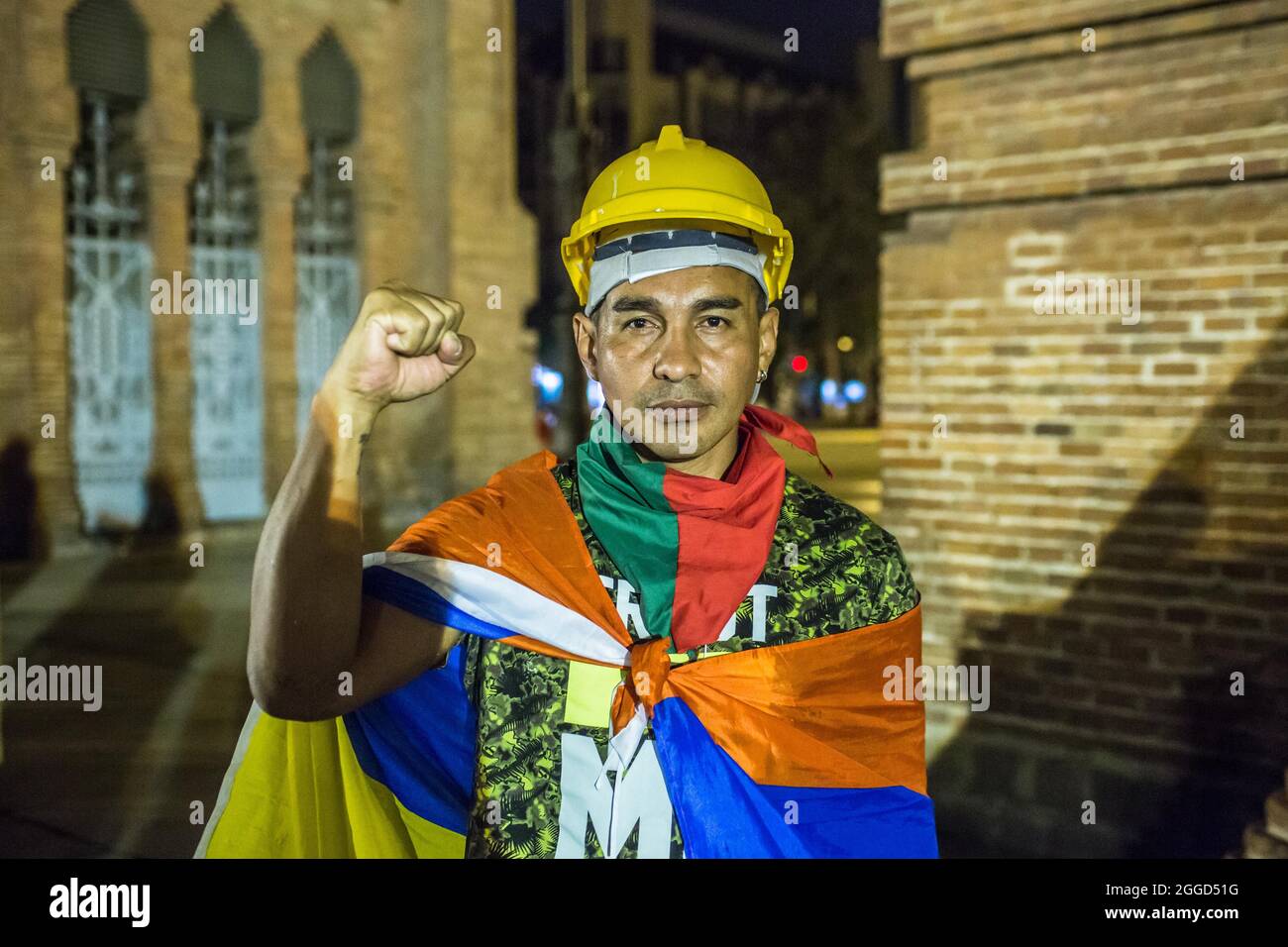 Barcelone, Espagne. 30 août 2021. Première ligne de défense dans les manifestations anti-gouvernementales en Colombie, Ricardo 'Prope' est vu avec son poing vers le haut. Environ 200 personnes ont manifesté devant l'Arc de Triomf de Barcelone contre les 6402 exécutions extrajudiciaires commises par l'armée dans le contexte du conflit armé colombien, un phénomène connu sous le nom de « faux positifs ». Crédit : DAX Images/Alamy Live News Banque D'Images