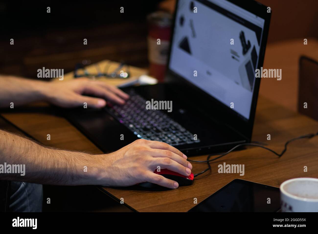 Adulte jeune personne dactylographiant et travaillant sur un ordinateur portable sur la table en bois Banque D'Images