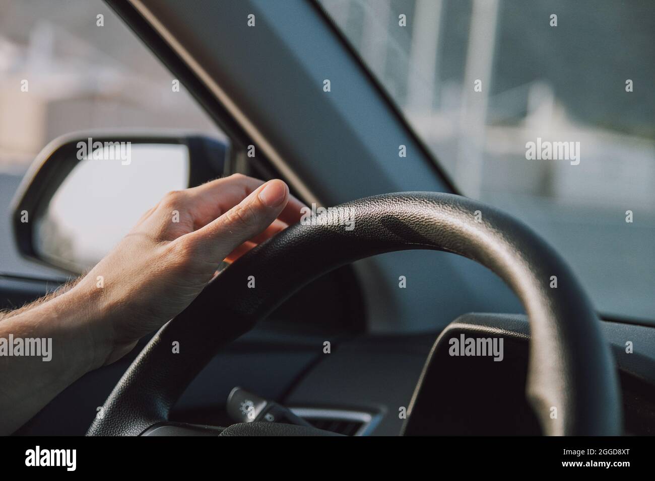 Jeune homme tenant le volant de la voiture Banque D'Images