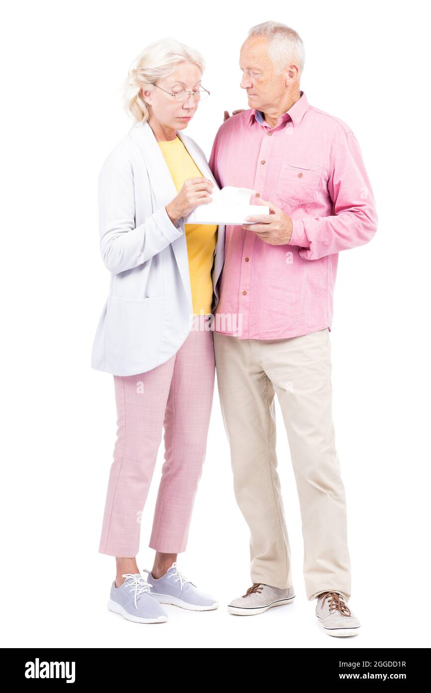 Plan conceptuel vertical complet de l'homme et de la femme âgés debout avec une boîte de serviettes en papier Banque D'Images