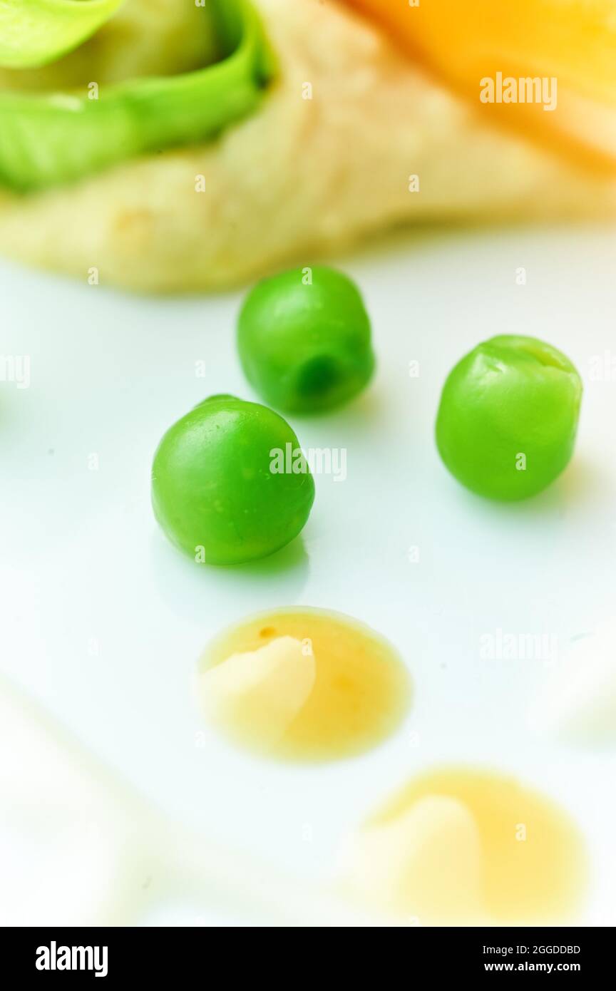 Asperges de printemps avec petits pois, carottes, humus de pois chickés de pamplemousse, miso mayonnaise et sauce au yaourt. Italie. Europe. Banque D'Images