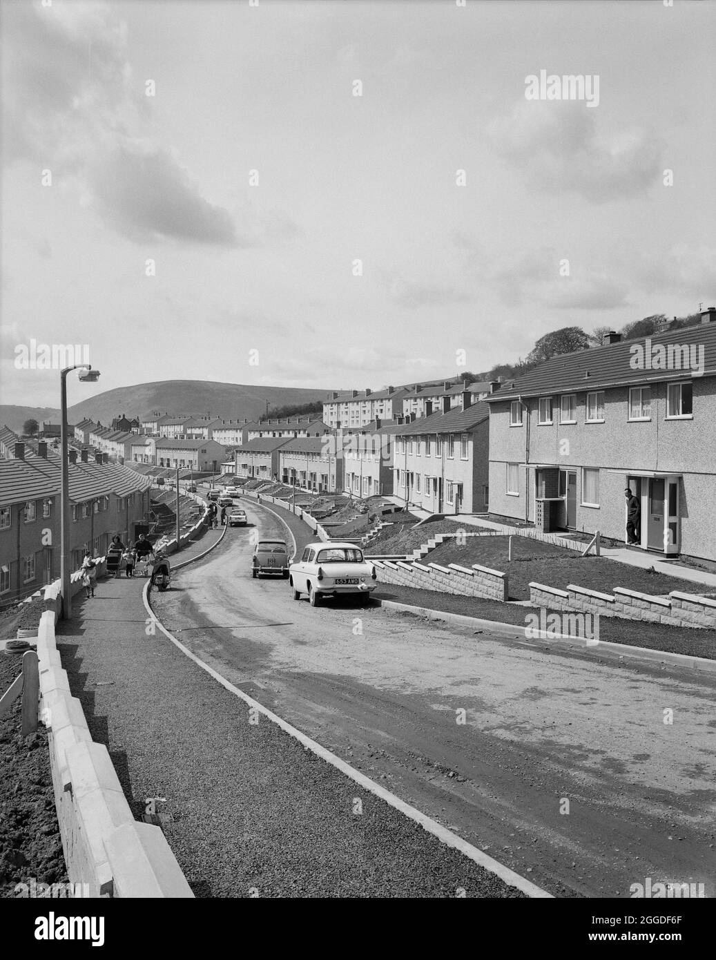 En descendant le long d'une rue sinueuse à Risca, montrant des rangées de logements en terrasses d'Easiforme. 'Easiforme' était une méthode de construction en béton coulé in situ que John Laing et son Ltd ont développée à partir de 1919. Banque D'Images
