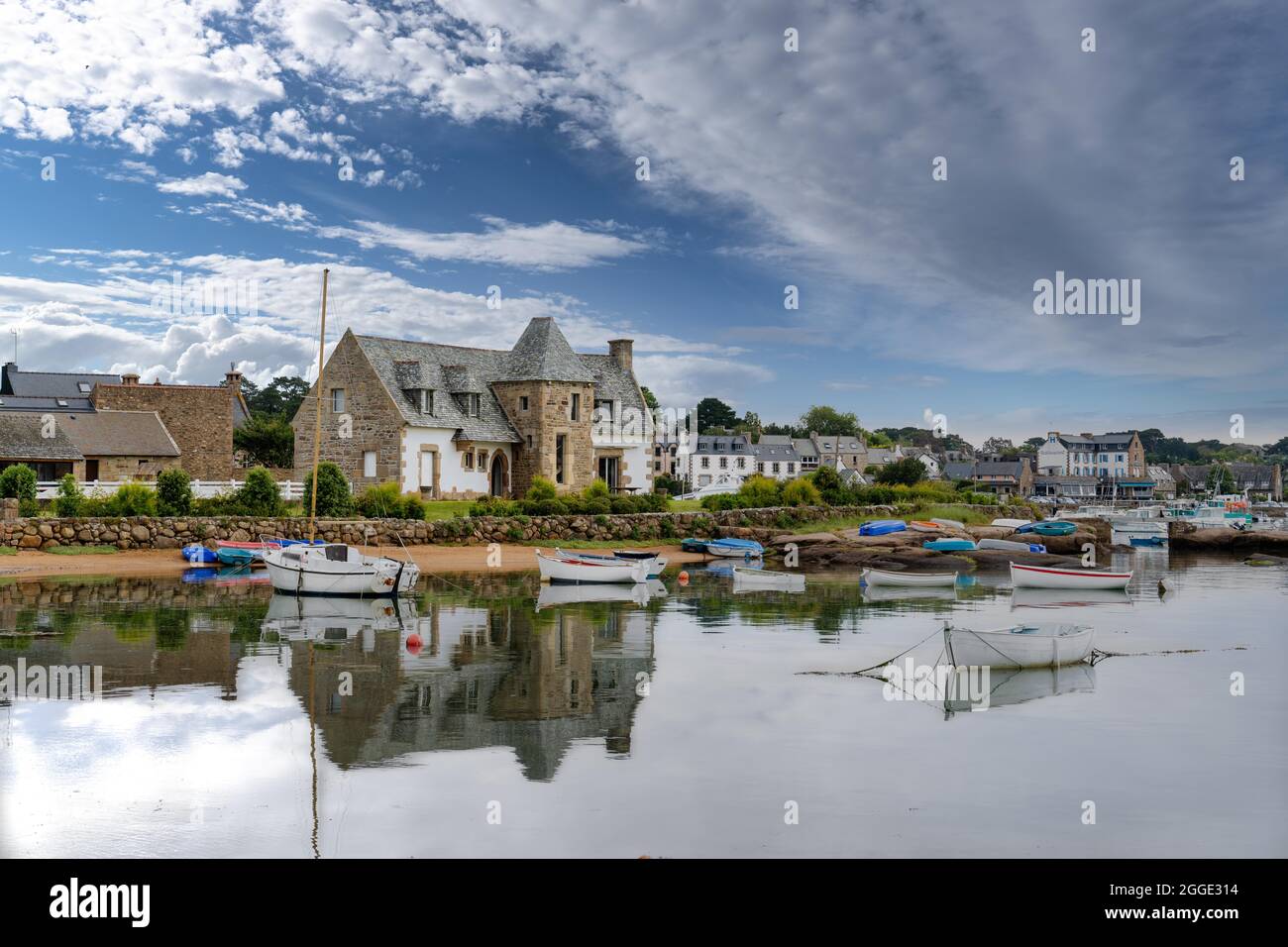 Le port de Tregastel avec bateaux de pêche, maison bretonne typique et ciel bleu, Bretagne, France Banque D'Images