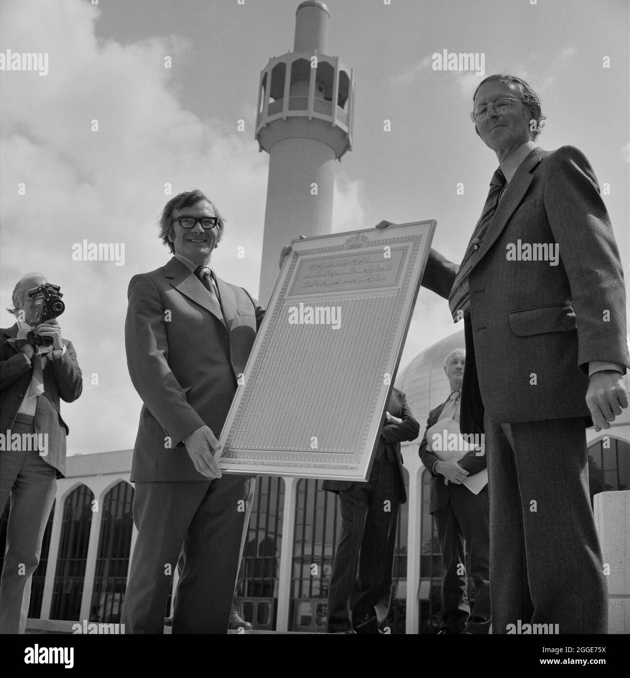 Mosquée centrale de Londres et centre culturel islamique, Park Road, Regent's Park, Cité de Westminster, Autorité du Grand Londres, 21/07/1977. Le chef de projet Peter Devine est présenté avec un imprimé encadré inscrit au Coran par l'architecte de projet Peter Hawker, dans la cour de la mosquée centrale de Londres le jour où les clés ont été remises au client. Cette image a été cataloguée dans le cadre du projet Breaking New Ground en partenariat avec la John Laing Charitable Trust en 2019-20. Banque D'Images