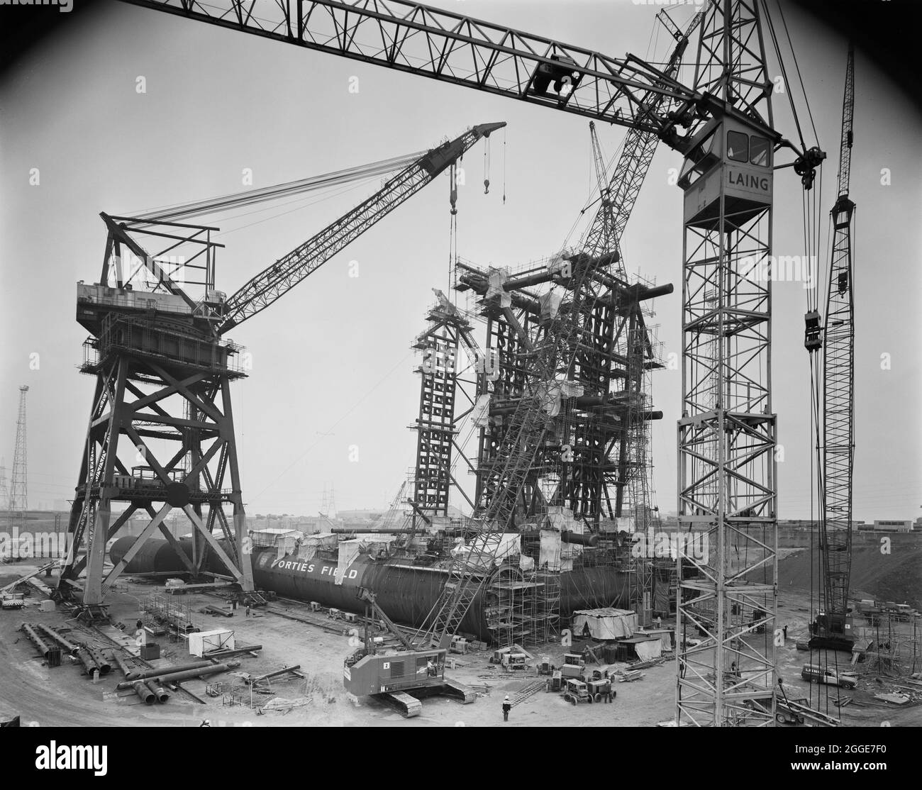 Vue de la construction d'une plate-forme pétrolière à Graythorp, montrant des grues autour de la structure émergente. Au début des années 1970, Laing pipelines Offshore a construit le chantier de fabrication Graythorp et le quai sec sur le site de l'ancien chantier naval William Gray. L'entreprise a créé un quai sec qui a été utilisé pour la construction de plates-formes fixes de forage en mer du Nord pour le projet pétrolier BP en mer du Nord. En 1972, un millier d'hommes travaillaient sur place pour construire une structure tubulaire qui soumettrait un engin de forage en mer du Nord destiné à l'Oilfield des Forties. Les grues sur place à Graythorp comprenaient t Banque D'Images