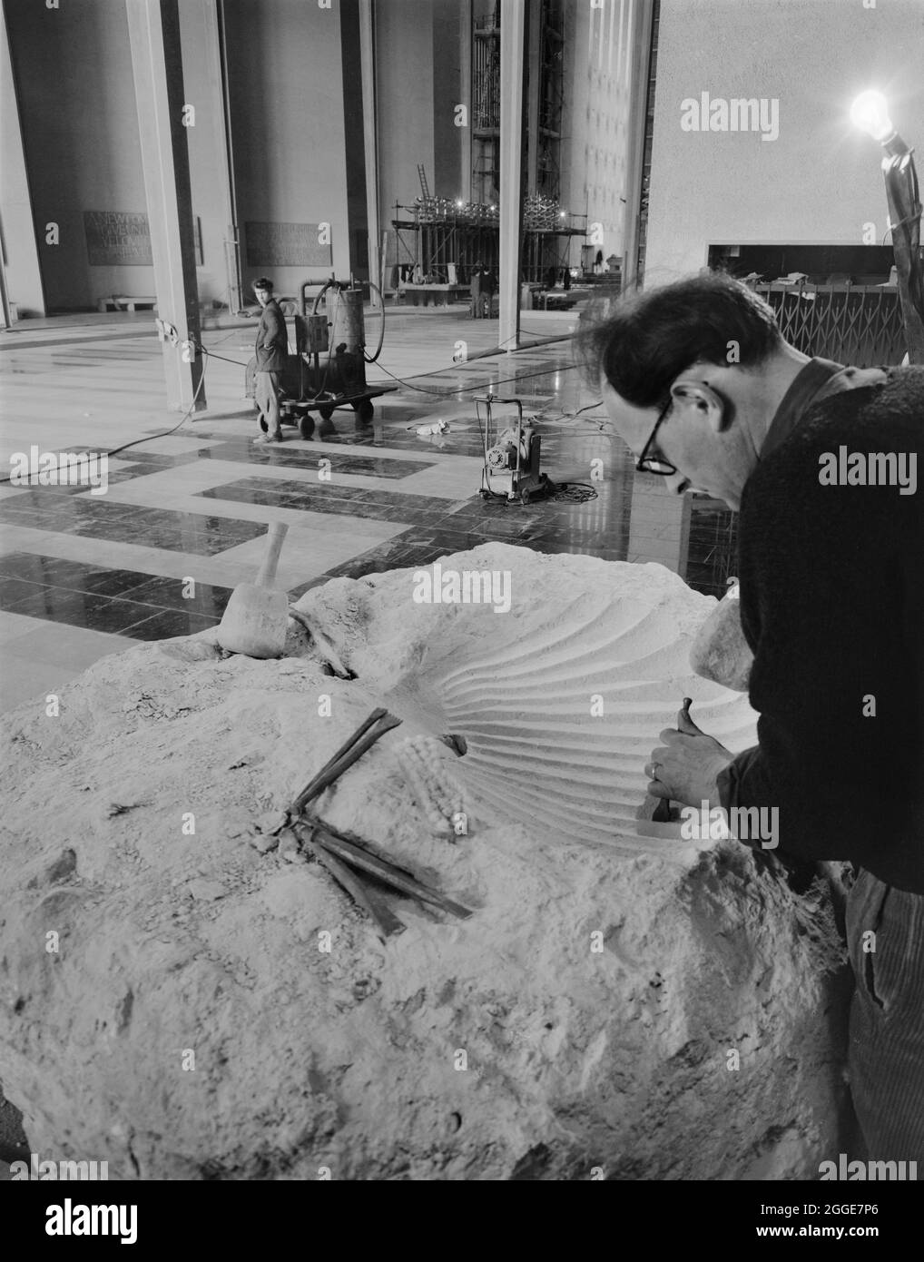 Ralph Beyer sculptant la police baptismal dans la cathédrale de Coventry. Ralph Beyer (1921-2008) était un sculpteur et un sculpteur de lettres qui a été commandé pour sculpter les inscriptions de la nouvelle cathédrale de Coventry construite entre le milieu des années 1950 et 1962. Il est vu ici sculpter la police baptismale d'un gros rocher qui avait été expédié de Bethléem, appelé Boulder de Bethléem quand il a été dévoilé à son arrivée à la cathédrale en 1960. Banque D'Images