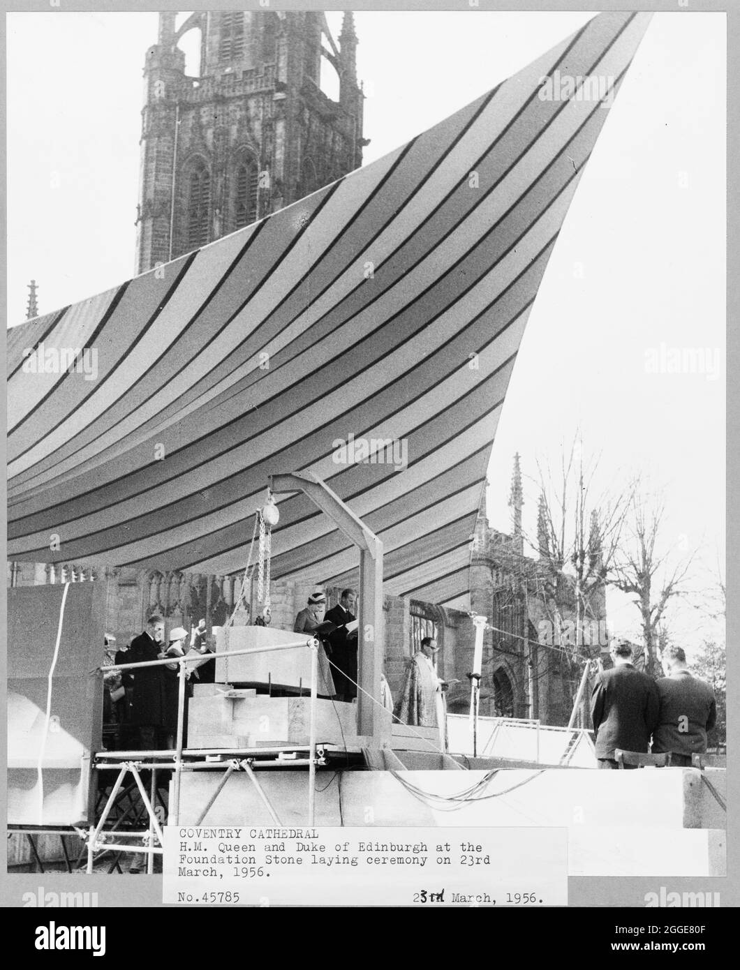 Vue de sa Majesté la Reine et du duc d'Édimbourg lors de la cérémonie de pose de pierres de fondation de la cathédrale de Coventry. Suite à l'attentat contre la cathédrale de Coventry en novembre 1940, un concours a été lancé en 1950 pour trouver un design pour une nouvelle cathédrale. Le dessin gagnant a été présenté par Sir Basil Spence (1907-1976) à partir de l'un des 200 dessins soumis. Des travaux de construction ont eu lieu entre le milieu des années 1950 et 1962. La reine Elizabeth II a posé la pierre de fondation le 23 mars 1956. Banque D'Images